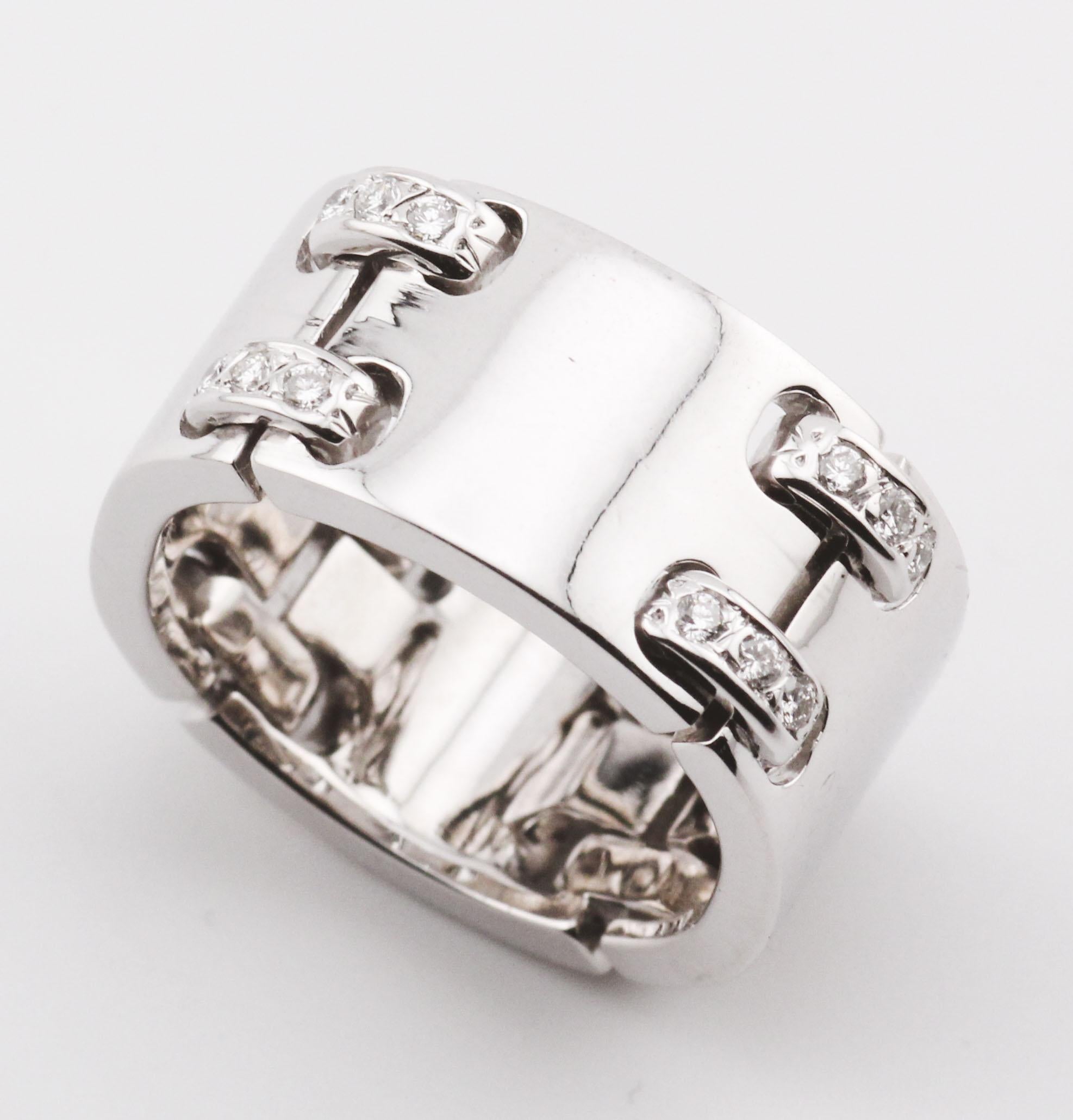 Questo anello a fascia di Hermès è un esempio di raffinata eleganza e di meticolosa lavorazione artigianale. Il design è caratterizzato da un'ampia fascia realizzata in oro bianco 18 carati, che offre una superficie elegante e lucida che emana