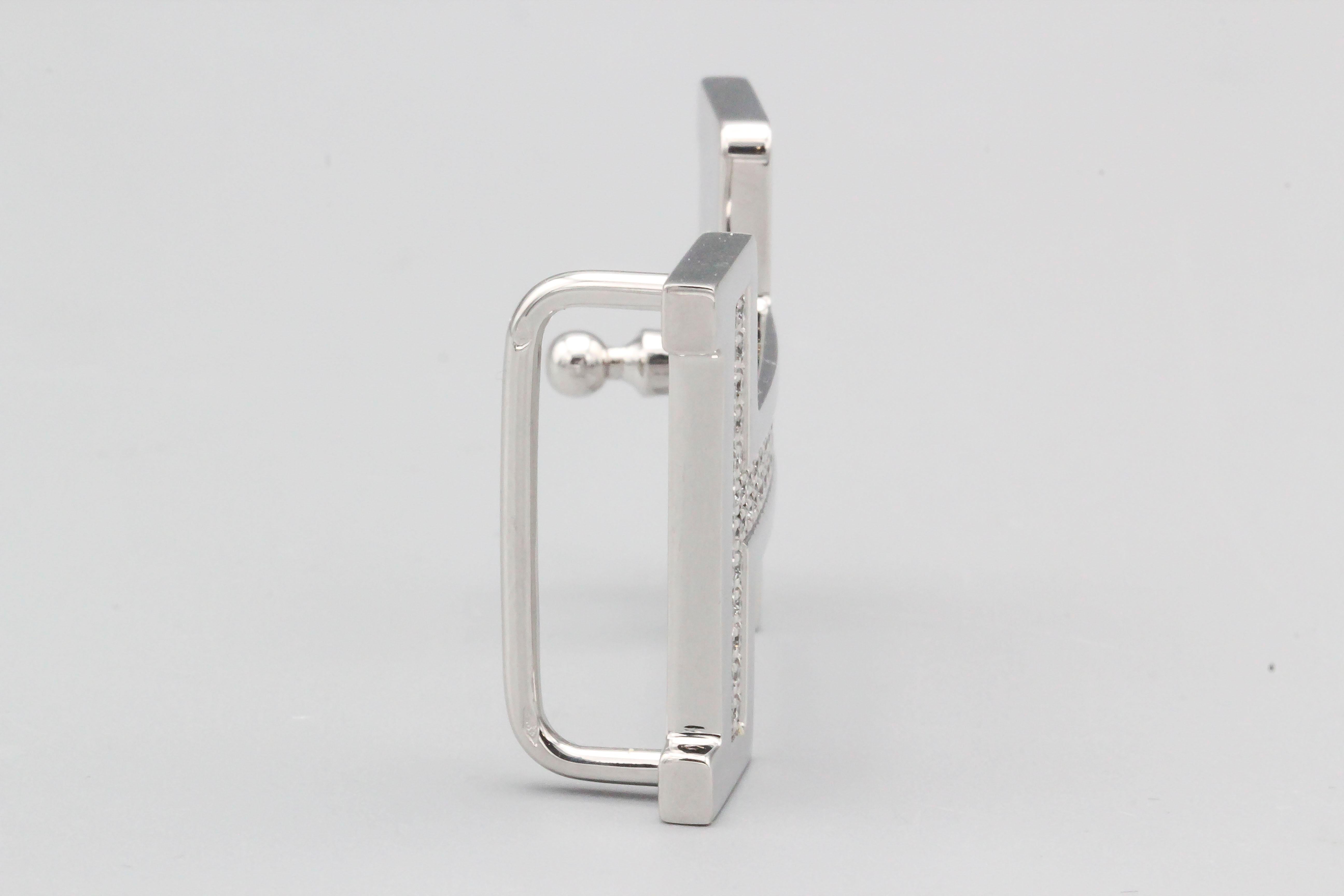Fine diamond and 18K white gold belt buckle by Hermes. It features the letter 