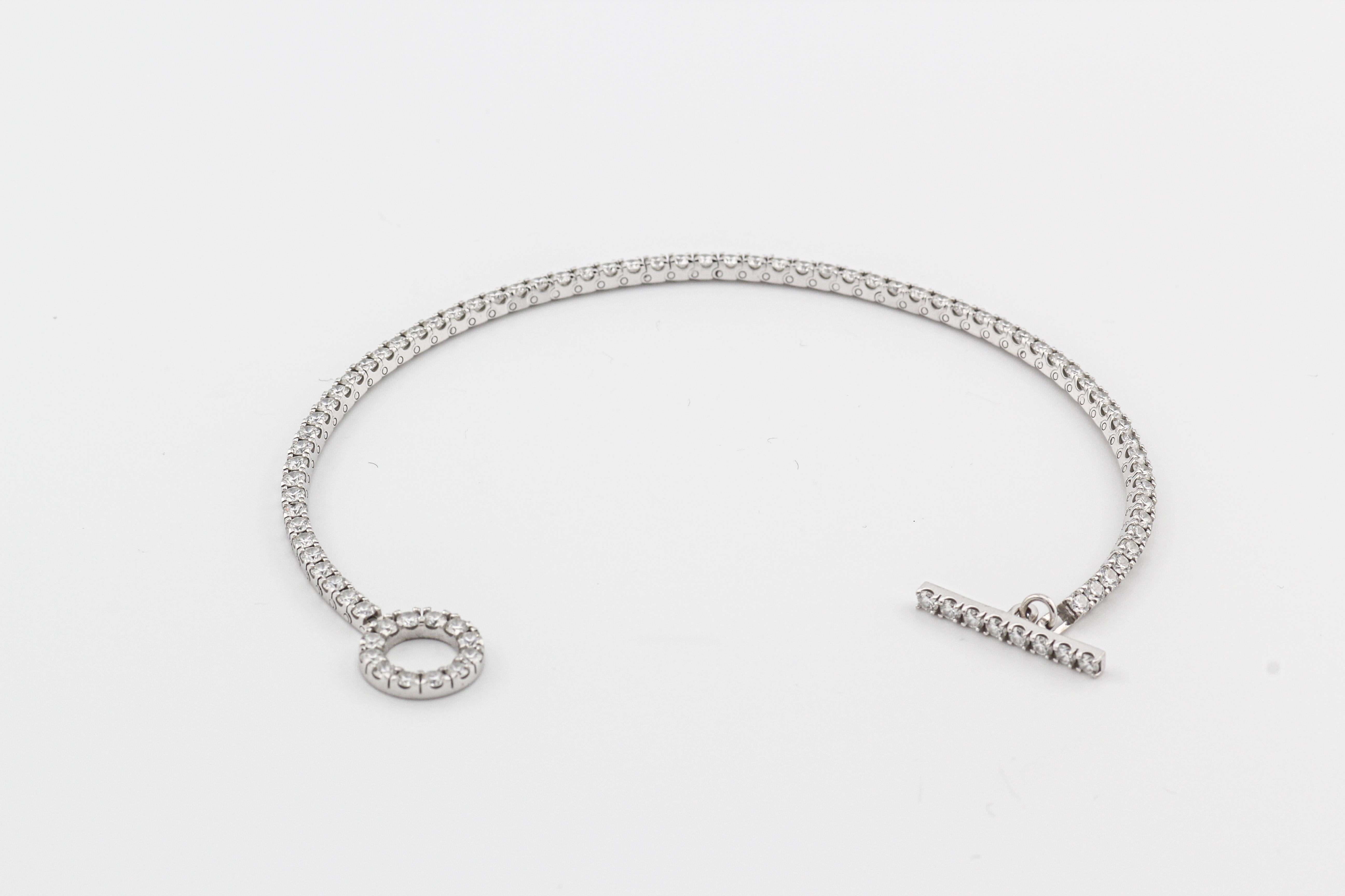 The Hermes Diamond 18k White Gold Finesse Toggle Tennis Bracelet is a dazzling and sophisticated piece of jewelry that effortlessly combines luxury and timeless elegance.  Crafted by the esteemed French luxury brand Hermes, this bracelet is a true