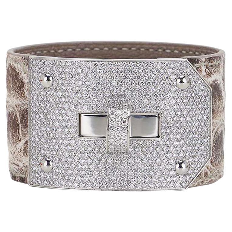 Mightychic propose un bracelet manchette Hermes Kelly à diamants unique avec 5 bracelets crocodile interchangeables.
493 diamants de taille brillant, 6,75ct sertis dans de l'or blanc 18k.
Il y a 5 sangles en crocodile au total pour compléter