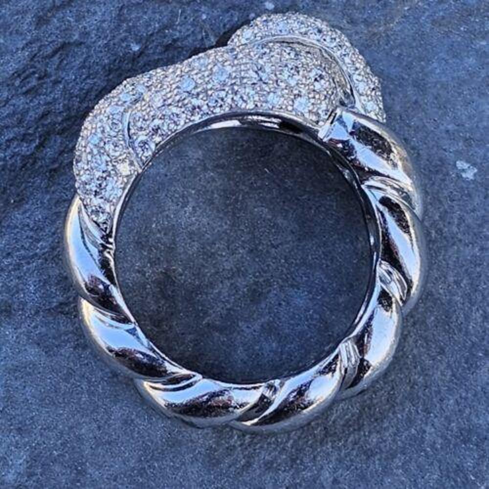 Cette superbe bague Hermès présente un magnifique nœud d'amour torsadé, réalisé en or blanc 18 carats et orné de diamants pavés étincelants. La bague est une taille 52 ou US 6.25 et est parfaite pour quelqu'un qui aime les bijoux uniques et luxueux.