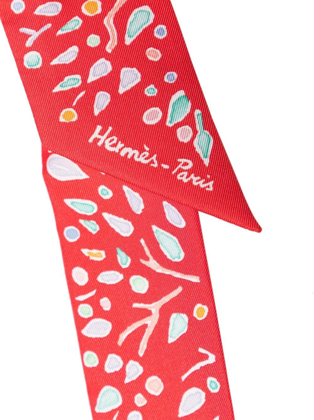 Questo vivace twilly rosso e bianco di Hermes è sapientemente realizzato in lussuosa seta francese. Questo pezzo versatile può essere indossato al collo, sulla testa, come accessorio da borsa e persino come bracciale. L'articolo è in condizioni