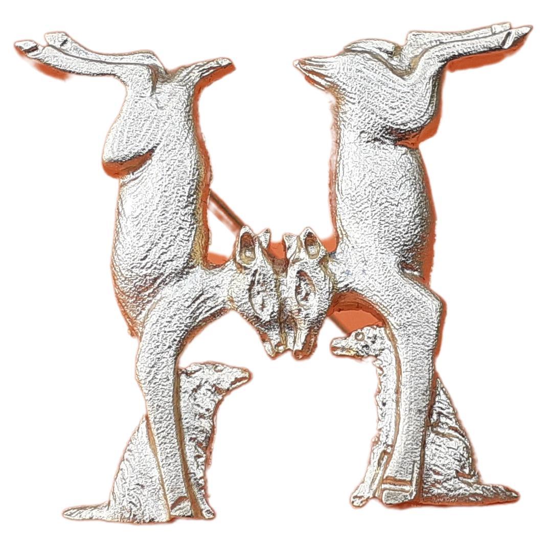 Beautiful Authentic Hermès Brooch

Pattern: Does and Dogs Forming an H

We can find this pattern on the Hermès Scarf called 