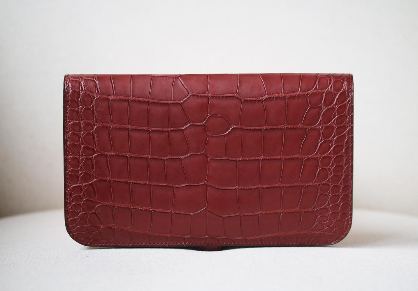 Wallet in Matte Bourgogne alligator-skin with lambskin lining. 5 credit card slots. 3 pockets. 1 removable change purse with zipper. Palladium plated Clou de Selle closure. Comes with original box. 

Dimensions: L 20.1 x H 12.5 x D 0.4