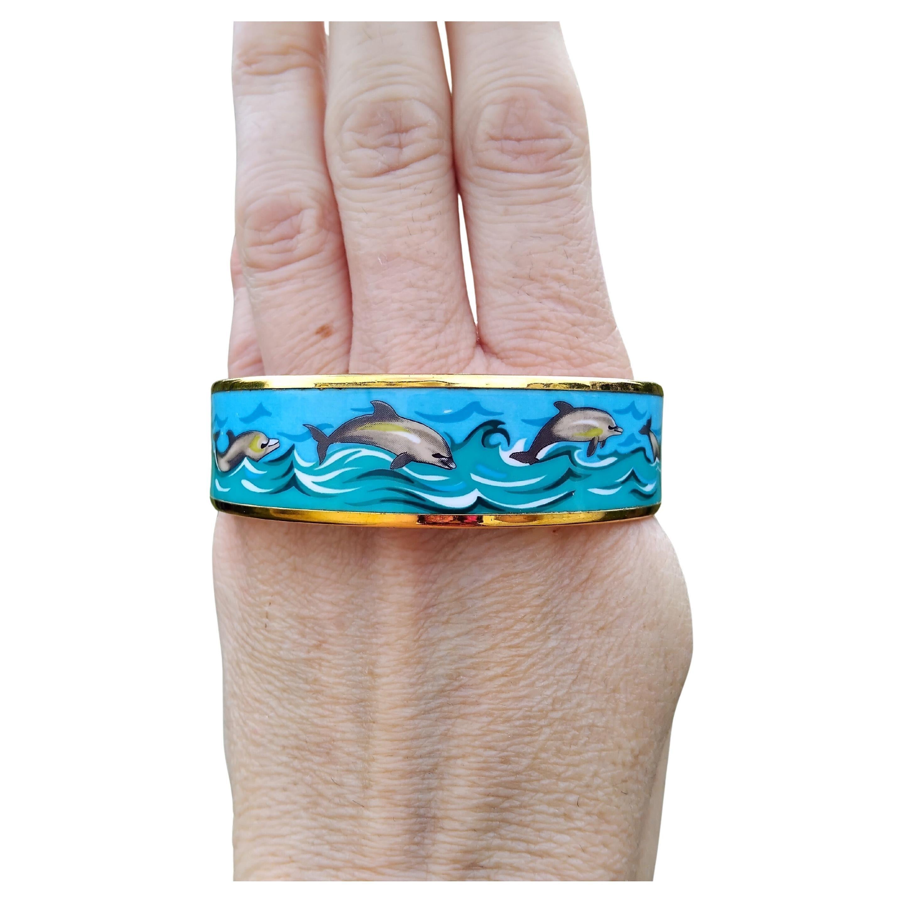 Lovely Authentic Hermès Bracelet

Print: Dolphins in Sea

Theme: dolphins, sea, navy

Rare bracelet, hard to find with golden hardware !

Made in Austria + C (1999)

Made of enamel and yellow gold plated Hardware

Colorways: Blue Sky, Green Sea,