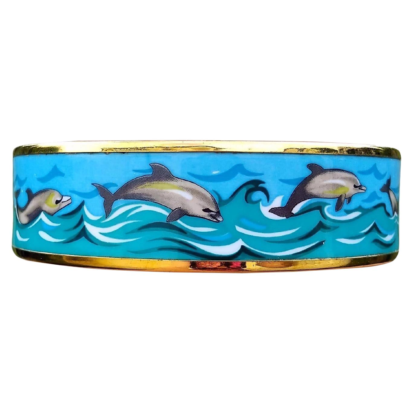 Lovely Authentic Hermès Bracelet

Print: Dolphins in Sea

Theme: dolphins, sea, navy

Rare bracelet, hard to find with golden hardware !

Made in Austria + C (1999)

Made of enamel and yellow gold plated Hardware

Colorways: Blue Sky, Green Sea,