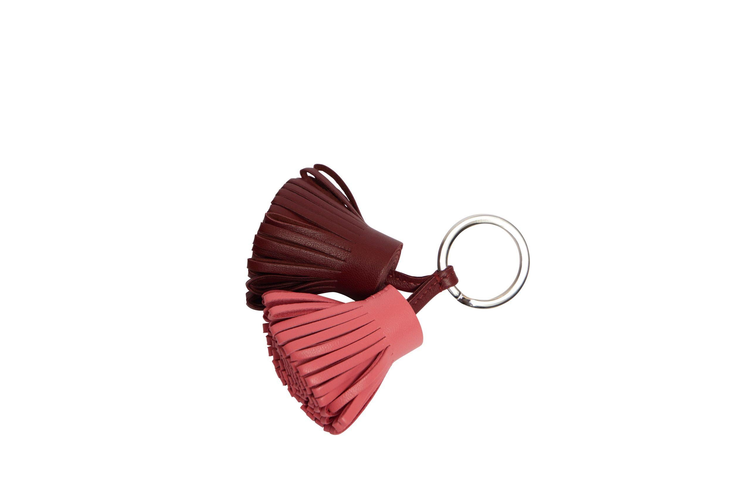 Hermès red and pink leather double Carmen tassel keychain. The ring is made of palladium metal. The piece is brand new and comes with the original box, ribbon and shopping bag.