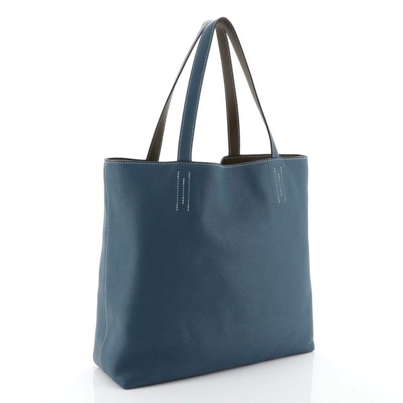 This Hermes Double Sens Tote Clemence 45, crafted from Colvert blue Clemence leather, features dual leather straps, white contrast stitching, and stamped Hermes logo. It opens to a Eucalyptus brown Sikkim leather interior. Date stamp reads: R