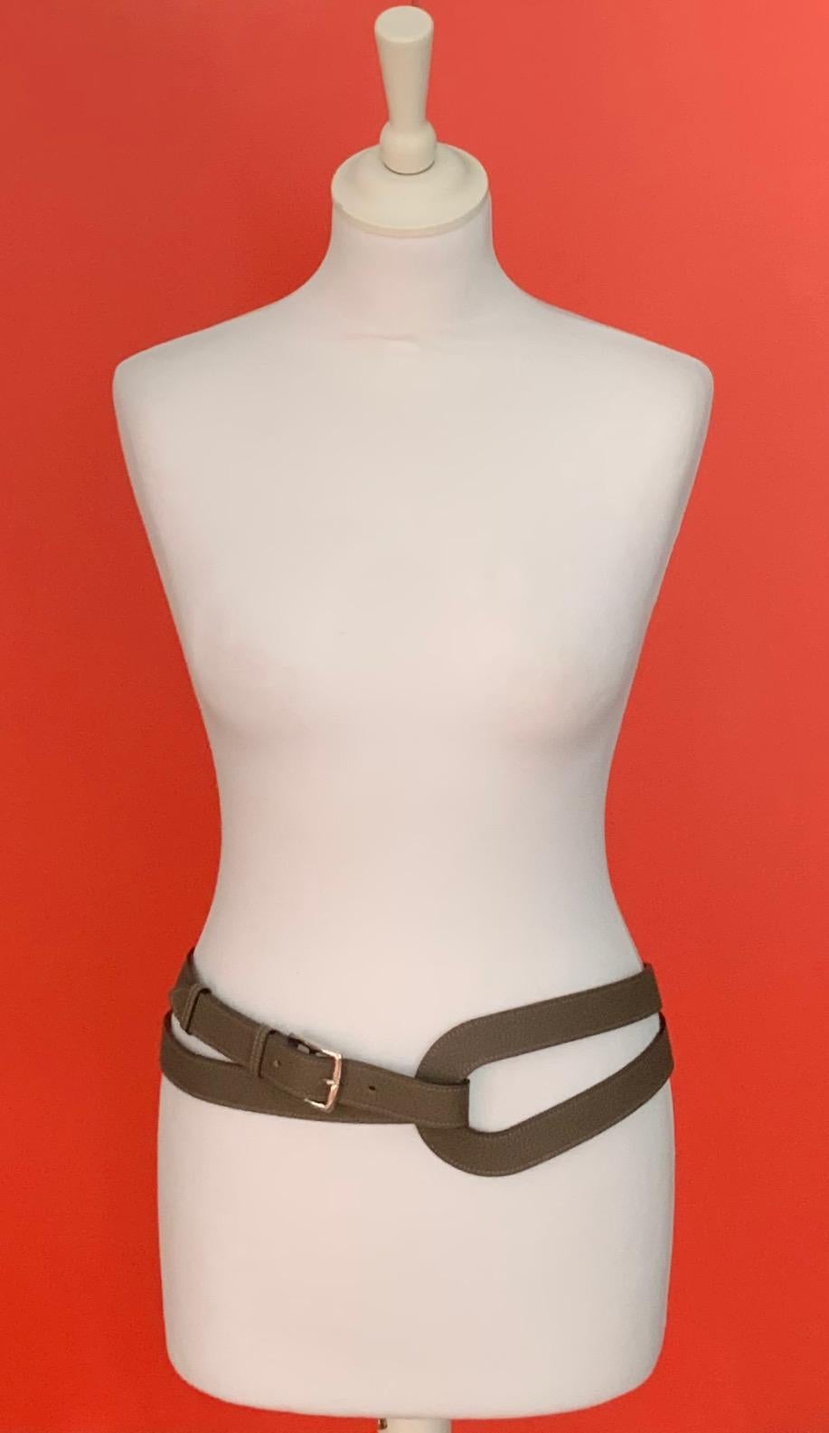 This pre-owned but new Double Tour belt model Circuit from Hermès has been designed by Jean-Paul Gaultier when he was the Artistic Director for the house.
It is crafted in a beautiful togo leather in Étoupe color with the buckle model Etriviere.