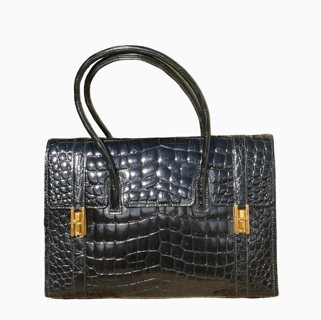 Superb and authentic Hermès Drag handbag in black porosus crocodile. It is in perfect condition as it has only been worn once.
Rare vintage model from the 60s.
Gold plated finish.
Double gold-plated “H” clasp on the flap.
Black lambskin lining