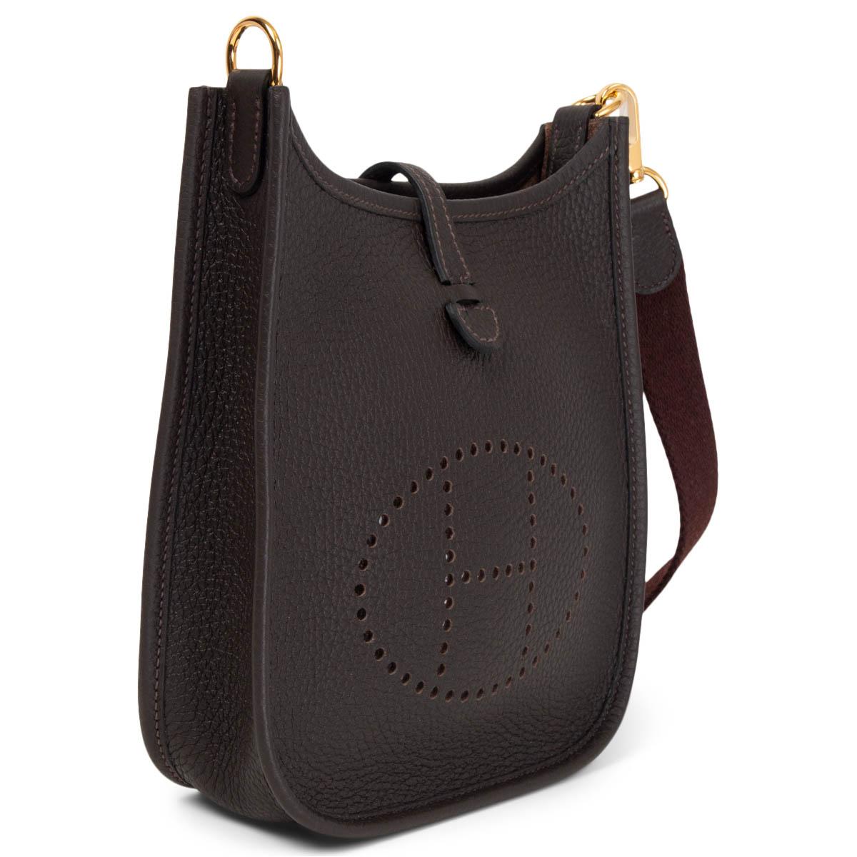 100% authentic Hermès Evelyne 16 Amazone crossbody bag in Ebene (dark brown) Taurillon Clemence leather with a Havane brown wool sangle strap, perforated leather 