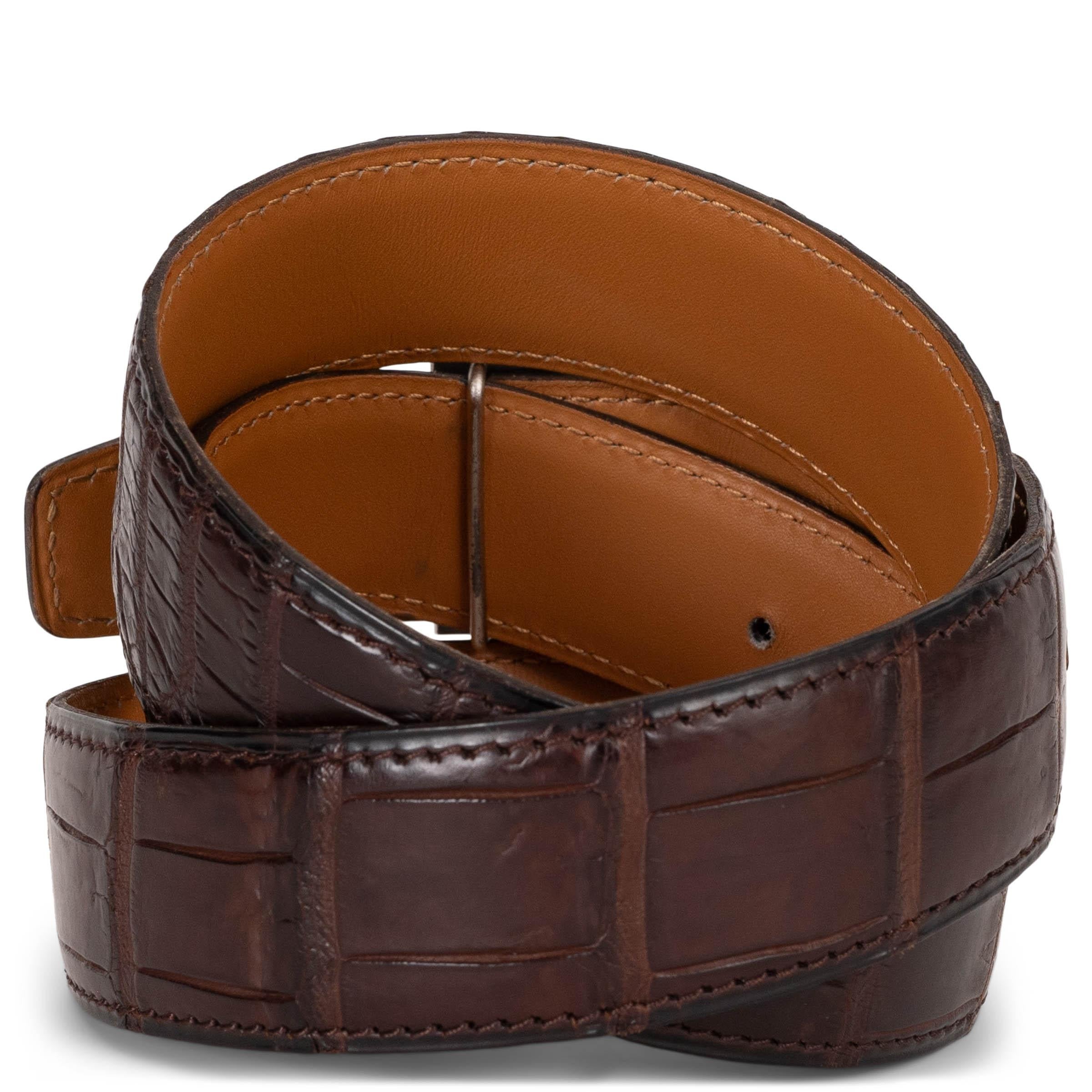This 100% authentic Hermès 32mm belt is crafted from Ebene (ebony brown) matte alligator crocodile leather and finished with the iconic H buckle in palladium. A timeless piece that epitomizes luxury and refinement. Has been worn and is in excellent