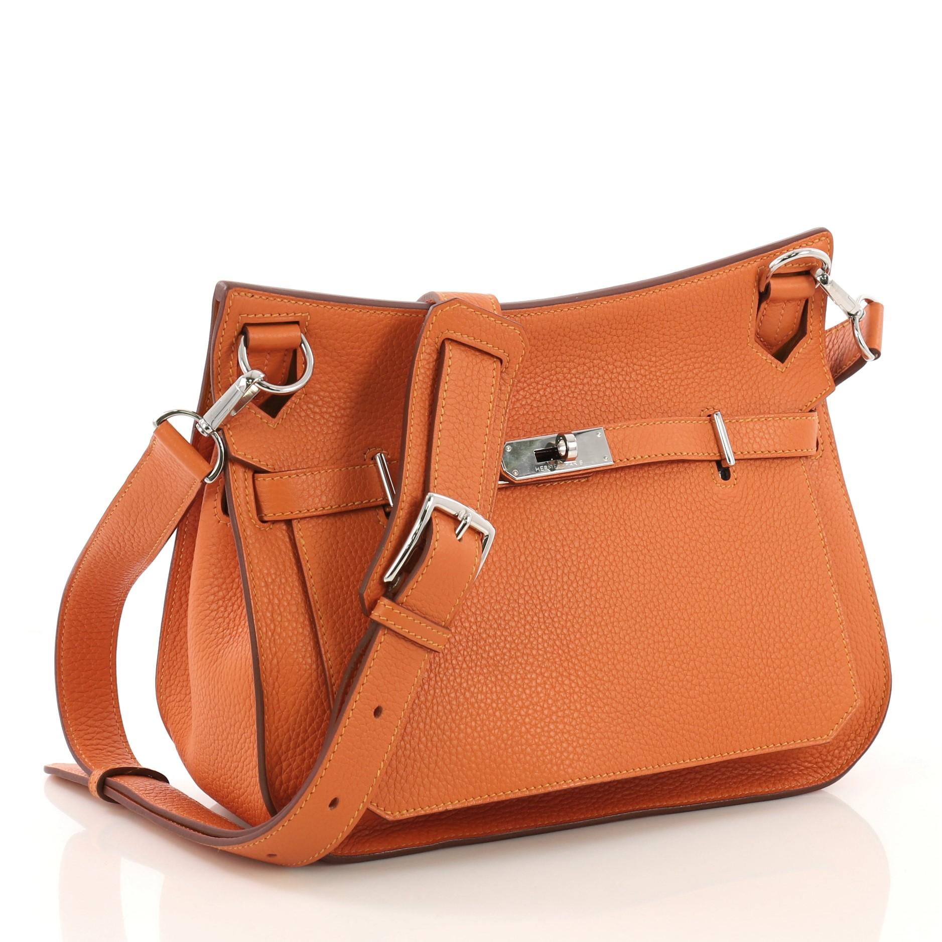 This Hermes Eclat Jypsiere Handbag Clemence 28, crafted in Orange H orange Clemence leather, features long adjustable strap and palladium hardware. Its turn-lock closure opens to a Moutarde Chevre leather interior with slip and zip pockets. Date