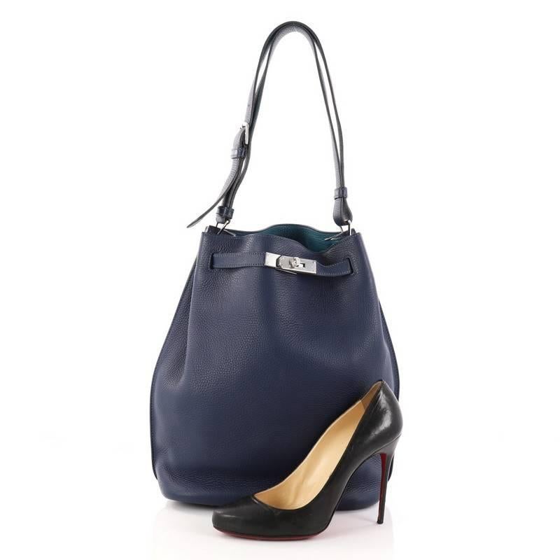 This authentic Hermes Eclat So Kelly Handbag Clemence 26 is an updated and modern reinterpretation of the Kelly Sport, taking its distinct look to Hermes' classic kelly design. Crafted in Bleu Saphir clemence leather, this luxurious hobo features