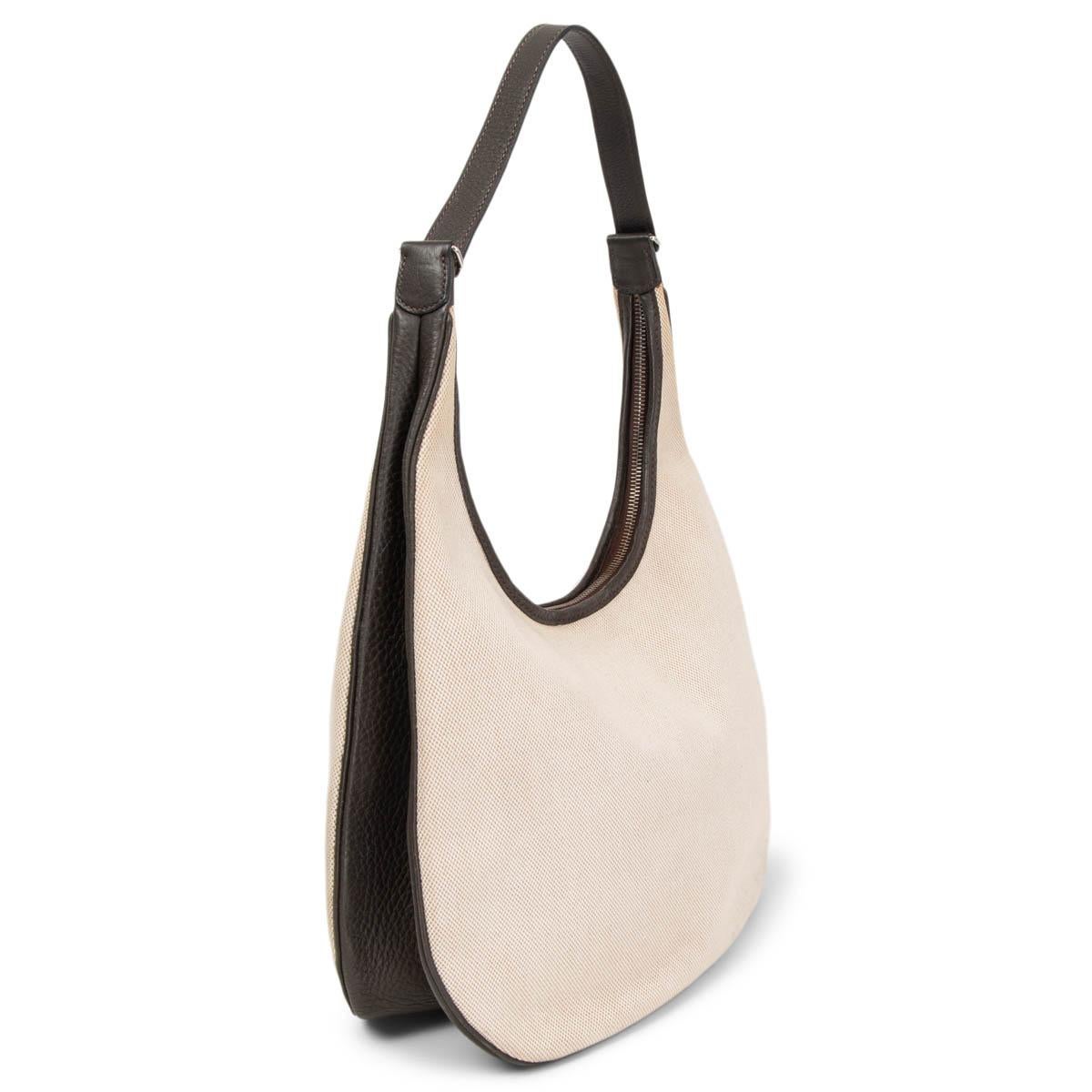 100% authentic Hermès Goa Hobo Bag in Ecur (off-white) Toile H canvas and Macassar (grey-brown) Taurillon Clemence leather. Opens with a zipper on top and is lined in off-white canvas with one zipper pocket against the back. Has been carried with