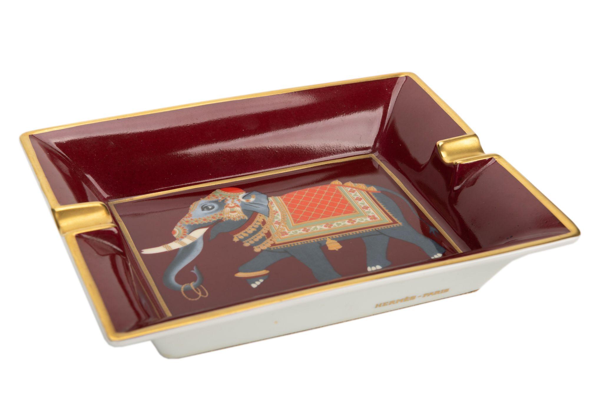 Hermès vintage ashtray in the main color burgundy. The center of the piece shows a print of a grey elephant with a colored blanket. Suede stamped bottom. The piece is in excellent condition.