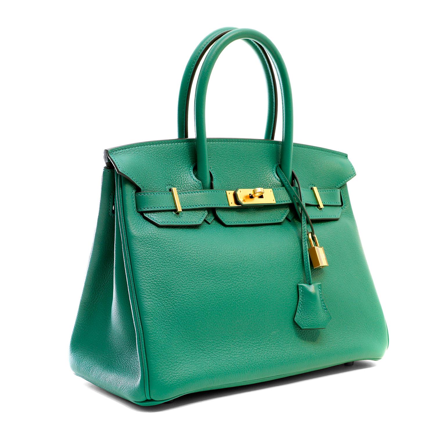 This authentic Hermès Emerald Green Evergrain 30 cm Birkin is in pristine unworn condition.  The protective plastic is intact on the hardware.  Hand sewn and coveted worldwide; the Hermès Birkin is considered the epitome of luxury handbags.