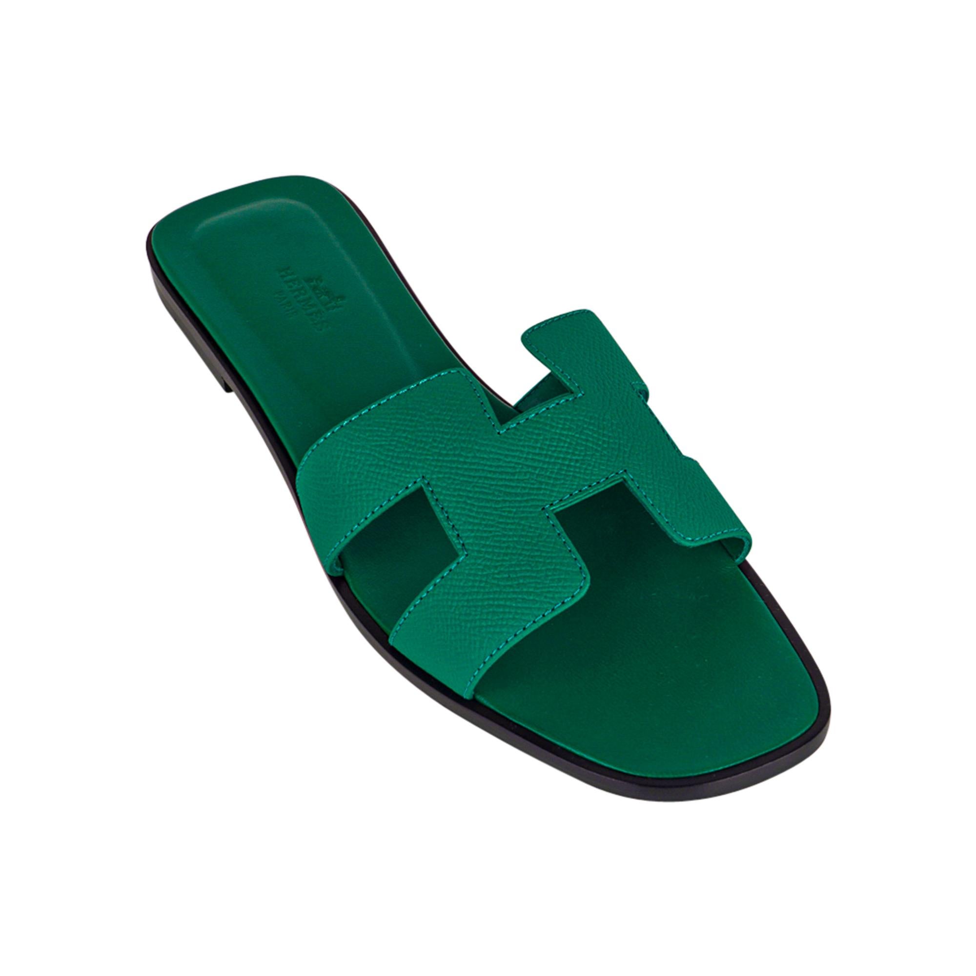 Mightychic offers limited edition Hermes Oran Emerald sandals.
This stunning limited edition Hermes Oran flat slide sandal is featured in Epsom leather.
The iconic H cutout over the top of the foot.
Emerald embossed calfskin insole.
Wood heel with