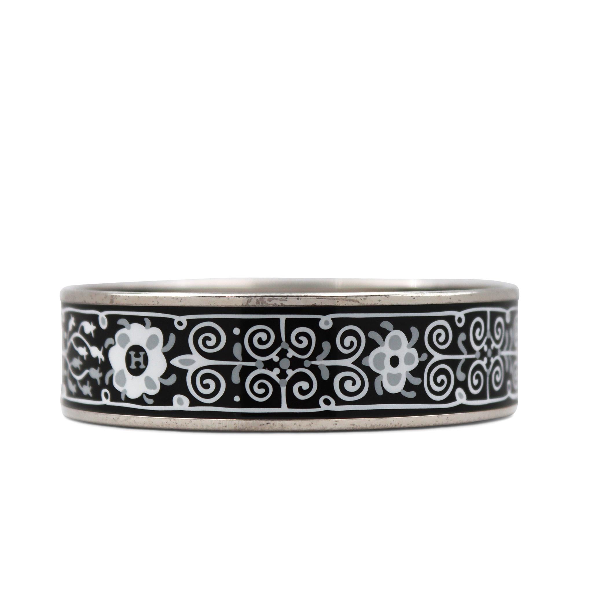 Authentic Hermès Paris bangle features black and white enamel work. The palladium coating shows minor signs of wear consistent with age and use. Signed Hermès Paris, Made in Austria, +K. The bangle is presented with the original pouch, no papers.