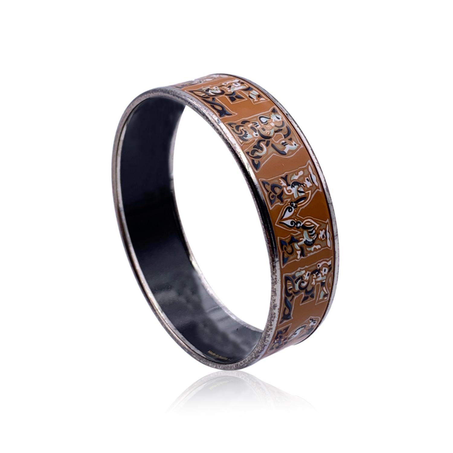 A truly stunning enameled 'Alphabet Russe' bangle bracelet by HERMES in beige color. Large Hermes lettering design. Black enameled interior. Inner diameter: approx. 2.5 inches -' 6.4 cm. HERMES Paris' & 'Made in Austria' embossed inside the