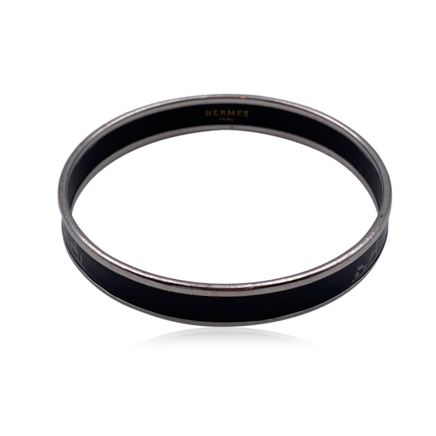 A stunning enameled 'Caleche' bangle bracelet by HERMES in black color. Iconic Hermes gig motif and palladium rim. Black enameled interior. Inner diameter: approx. 2.5 inches -' 6.4 cm. HERMES Paris' & 'Made in Austria' embossed inside the