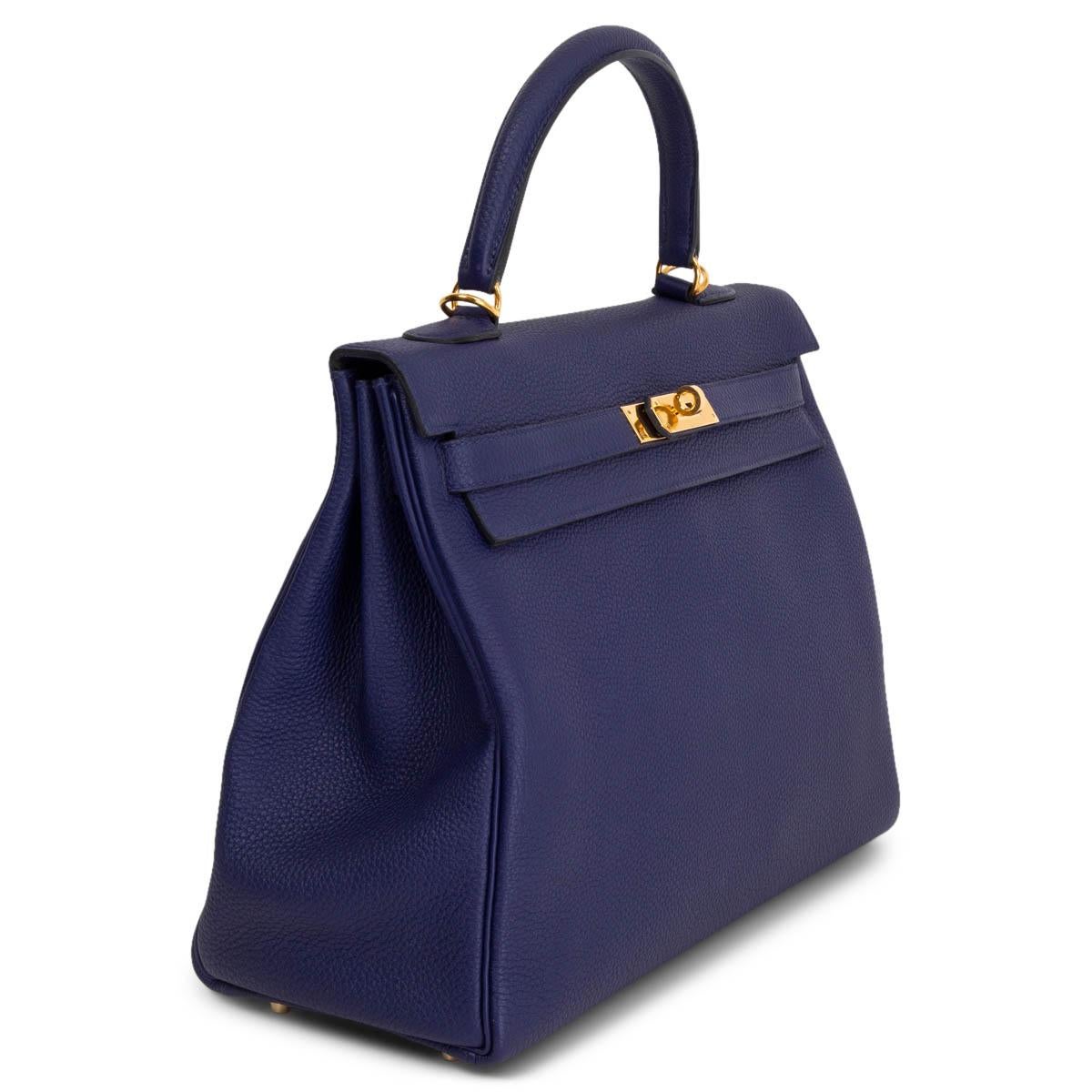 100% authentique Hermès Kelly 35 sac à bandoulière en cuir Bleu Encre Togo avec matériel doré. Doublé en cuir de chèvre Bleu Saphir avec deux poches ouvertes à l'avant et une poche zippée à l'arrière. A été porté avec des signes d'utilisation