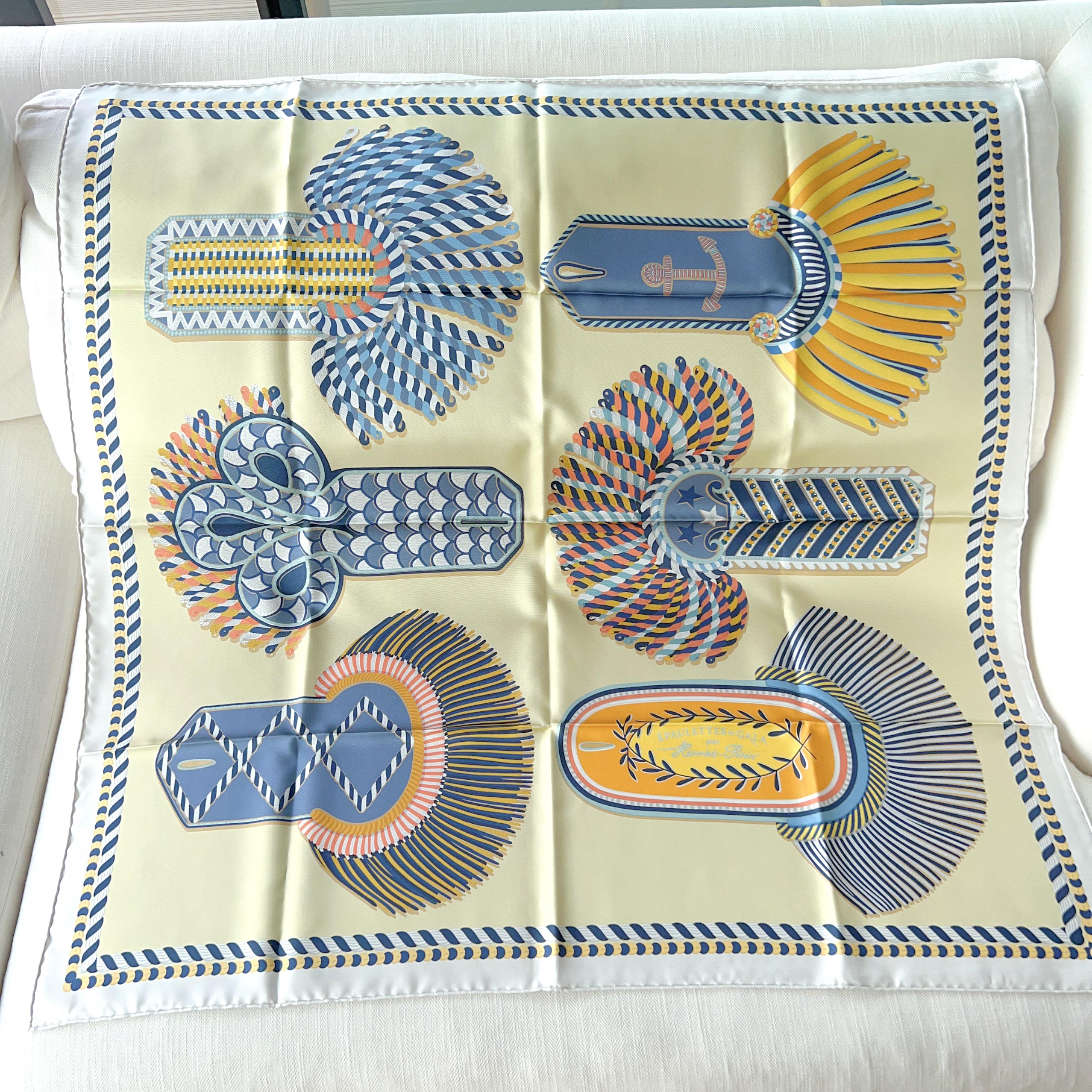 Shop this Hermes Epaulettes de Gala Double Face 90 in Gris Perle / Jaune Pâle / Gris Bleuté. This scarf design is the first that is printed on both sides allowing you to change sides for a new style. The design depicts epaulettes that you see on the