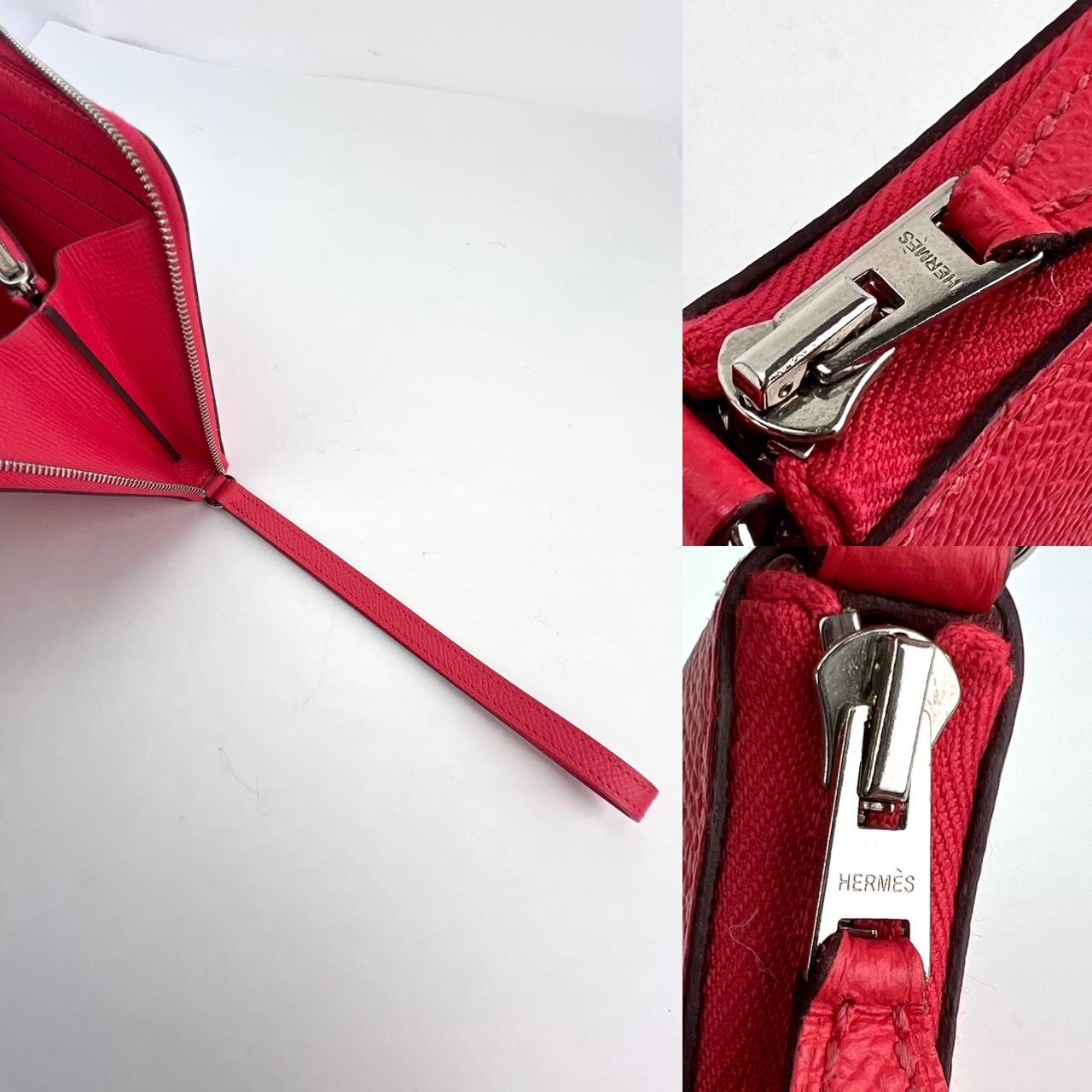 This stunning wallet is crafted of epsom calfskin leather in red/pink. 
A palladium zipper opens to a partitioned matching leather interior 
with credit card slots and a central zipper pocket. This wallet has
 a wrist strap that makes it both
