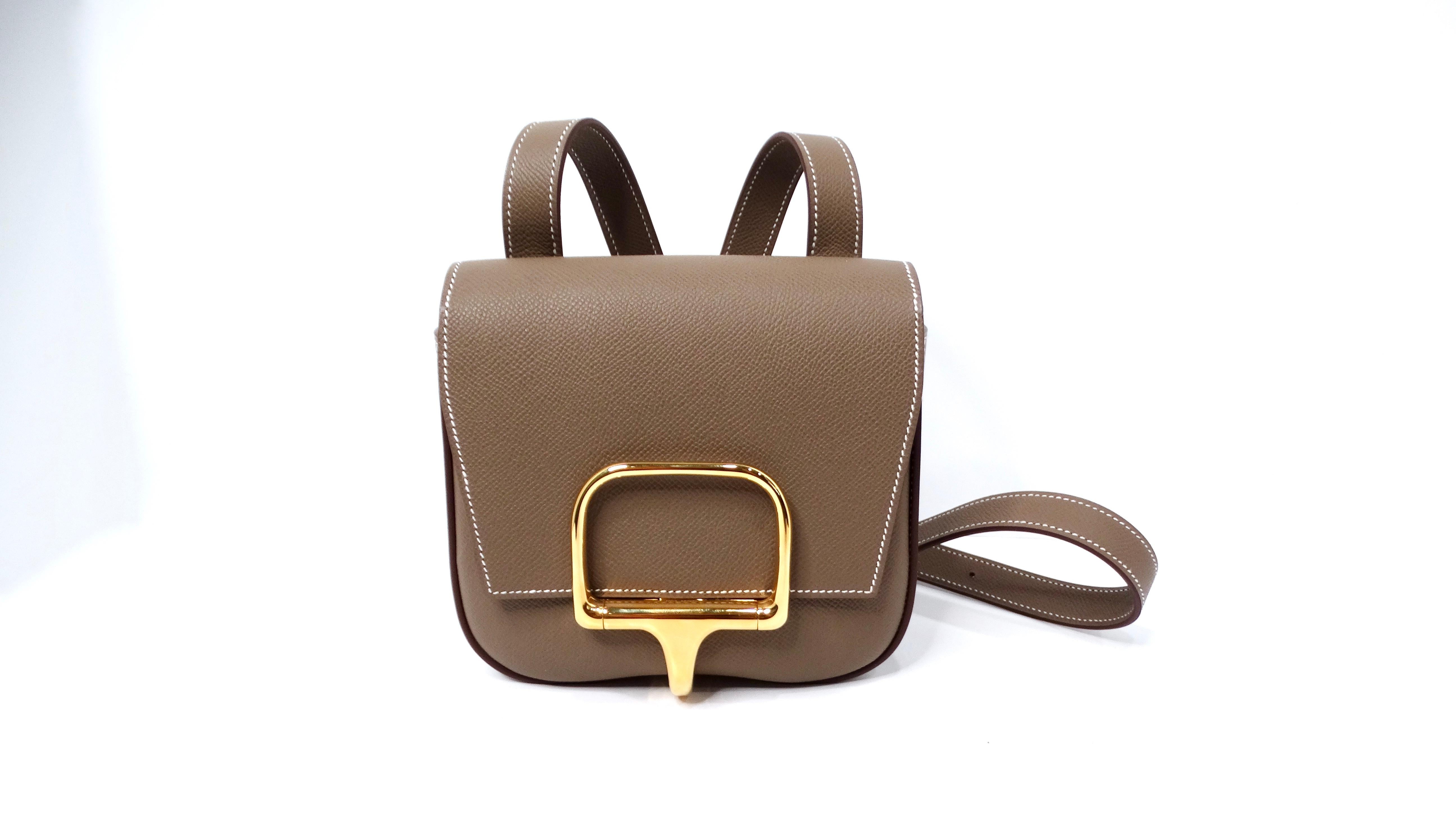 The Hermès Epsom Mini Della Cavalleria Eutoupe Crossbody Bag epitomizes understated luxury and refined practicality. Crafted from premium Epsom leather, this bag flaunts a sophisticated Gray Eutoupe hue that effortlessly complements a range of