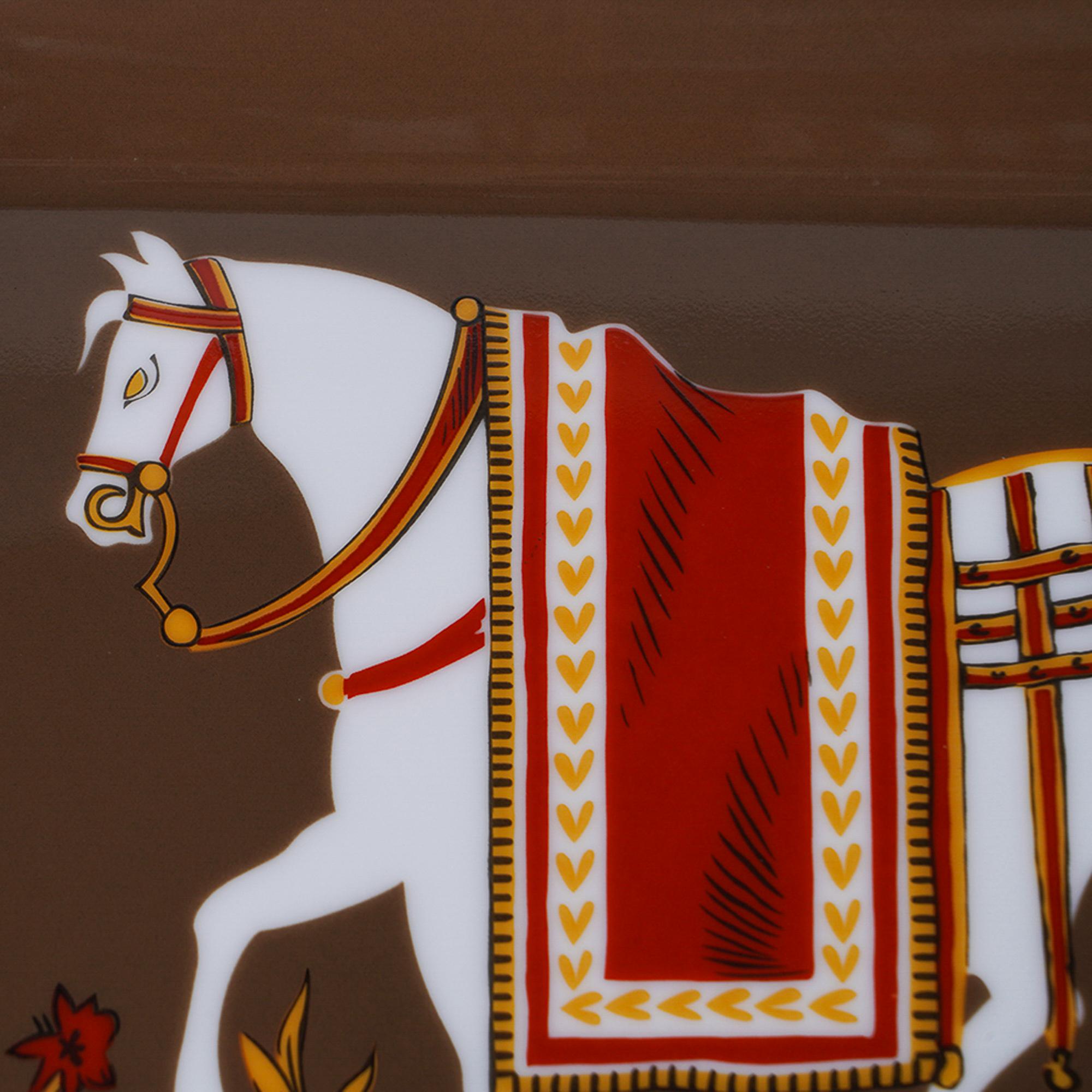 Mightychic offers a rare vintage Hermes Chevaux à la Couverture Change Tray.
A beautiful warm brown offsets the delicate features of the white horse.
Accentuated with red details.
Hand painted gold trim.
A perfect accent piece for any