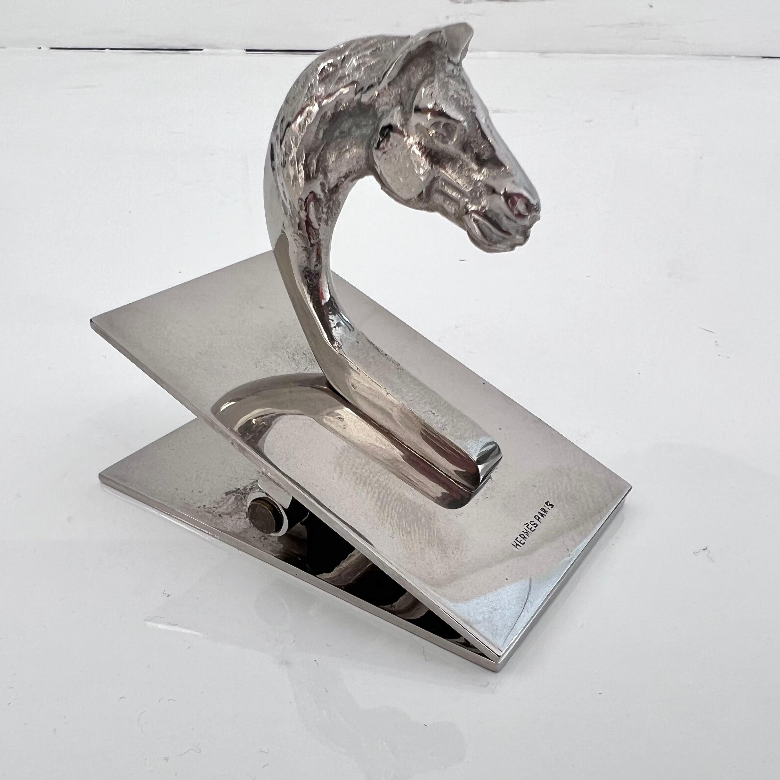 Substantial Hermès paper clip with a detailed horse head handle in solid metal. Hermès Paris stamped on the top. Light patina to silver. Large scale with good weight to it. Only one available. Beautiful tabletop piece. Great piece of collectible