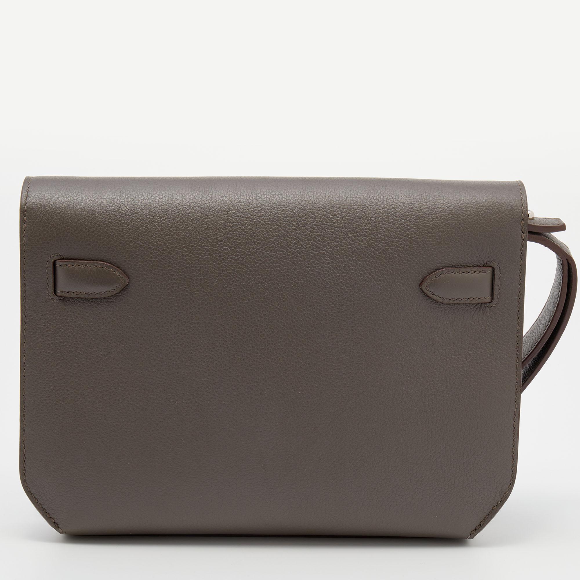 This Hermes Kelly Depeches 25 pouch can be elegantly carried in your hand or tucked under your arm. It is made using Etain Evercolor leather into a classy shape and elevated with a Kelly lock on the front. The interior is lined with