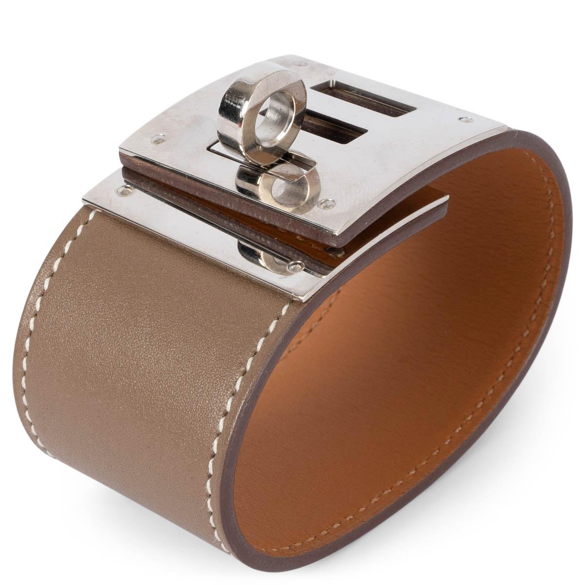 100% authentic Hermès Kelly Dog Extreme cuff bracelet in Etoupe (taupe) Swift leather featuring contrasting white stitching and Palladium hardware. Has been worn and and is in excellent condition. Comes with velvet pouch and box.

Measurements
Tag