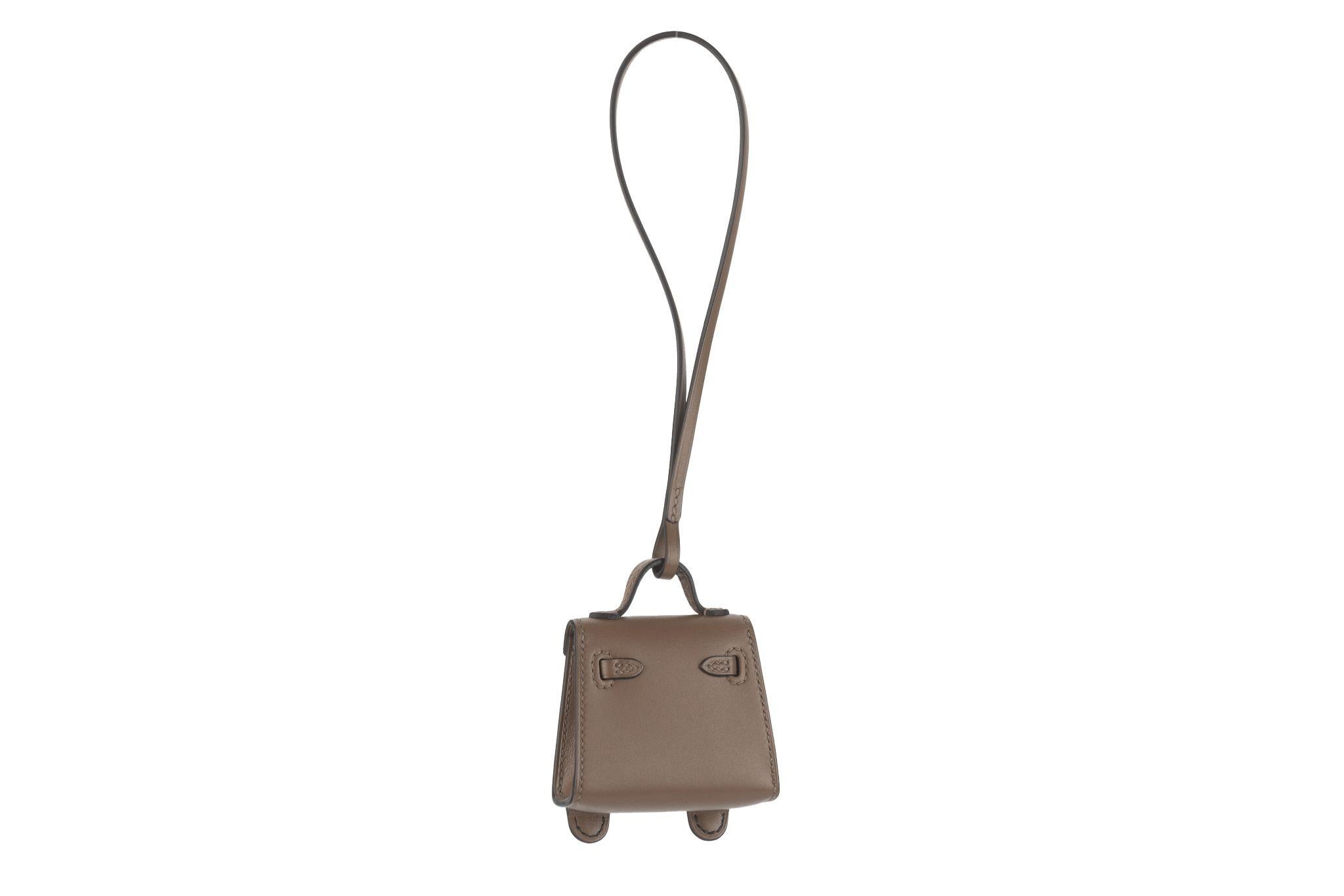 Hermès quelle idole kelly doll bag charm. Etoupe, nata, noir chevre mysore and tadelakt leather, gold tone hardware. Highly collectible and limited edition charm. Comes with original dust cover.