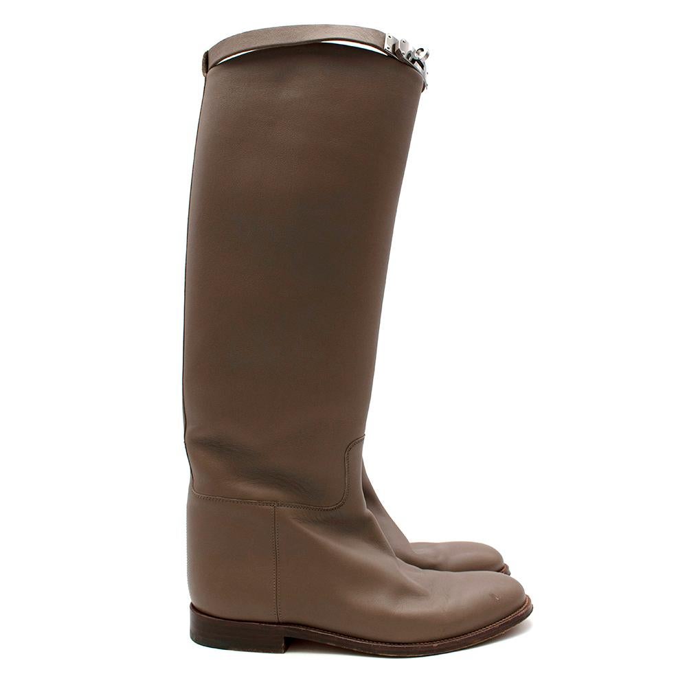 Hermes Jumping Boots With Kelly Strap

- Soft and structured thick calfskin
- Tanned inner lining
- Iconic palladium plated buckle Kelly strap at the top of boot in silver
- Slight wooden heel and sole around the boot
- Almond shaped toes
- Hermes
