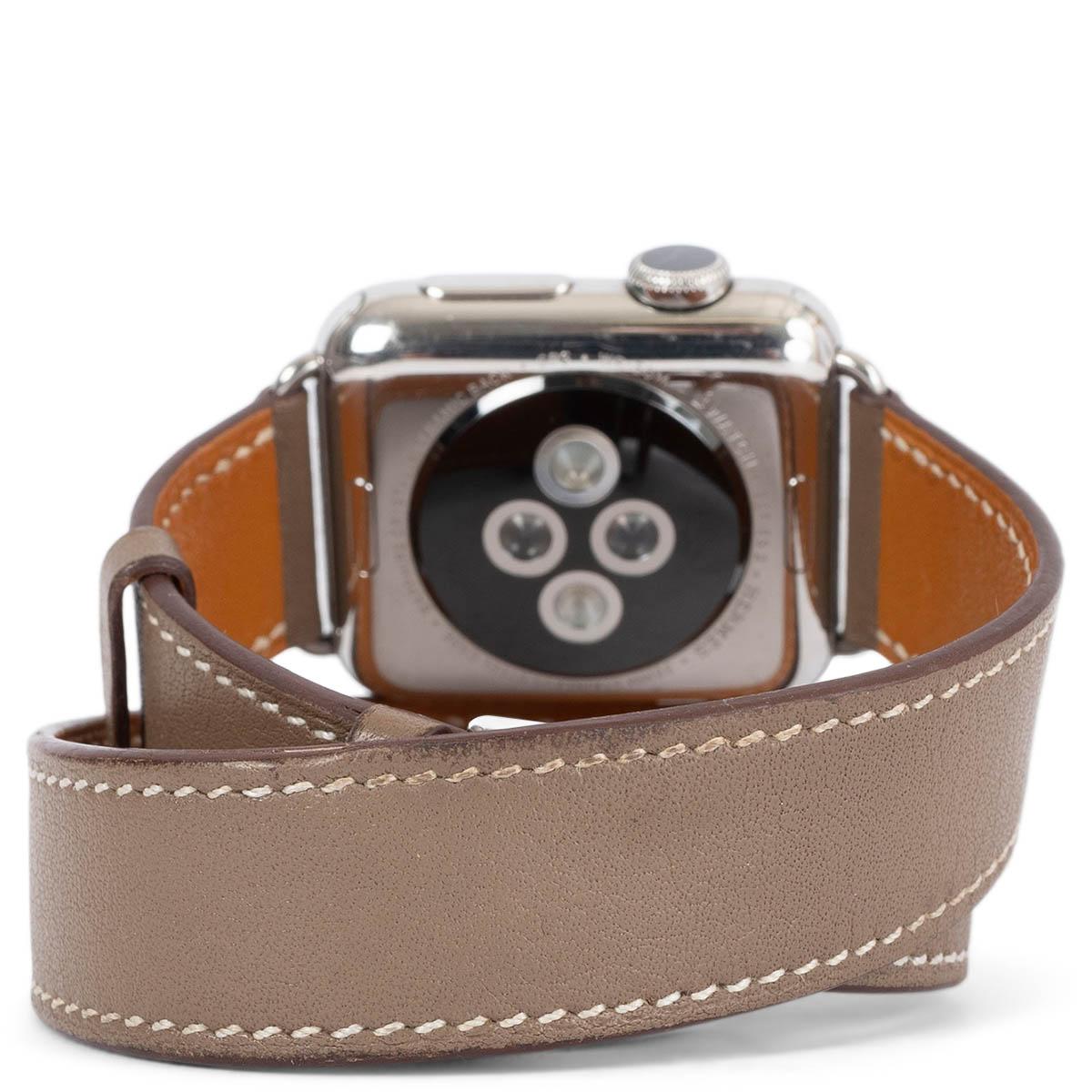 100 % authentique Apple Watch Hermès en acier inoxydable avec bracelet interchangeable en cuir Barénia double enveloppe (taupe) et bracelet sport en caoutchouc orange. A été porté et est en excellent état. Livré avec chargeur et