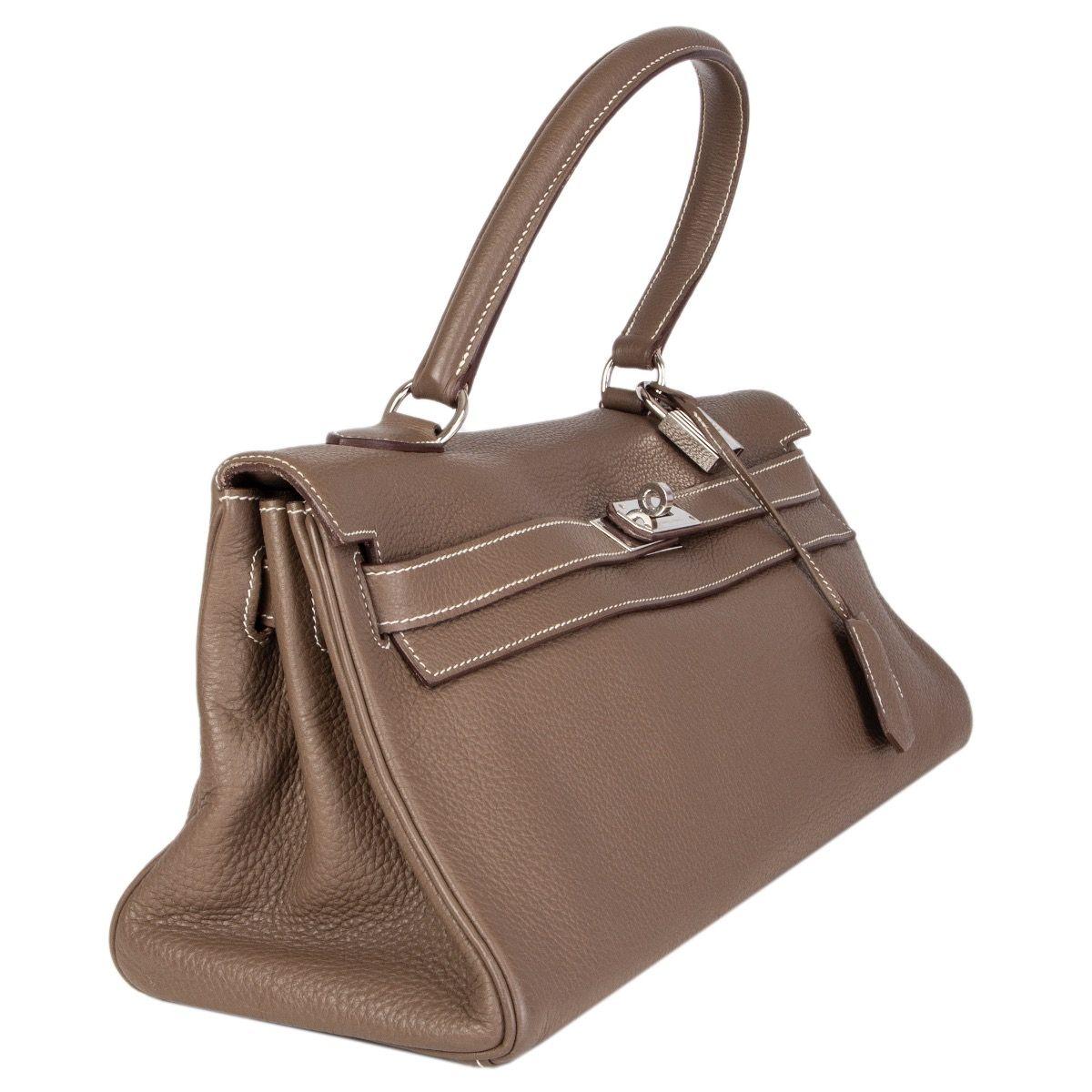 Hermes 'JPG Kelly 42' in Etoupe (taupe) Taurillon Clemence leather with contrasting white stitching. Opens with a turn-lock and straps on the front. Lined in Chevre (goat skin) with two open pockets against the front and a zipper pocket against the