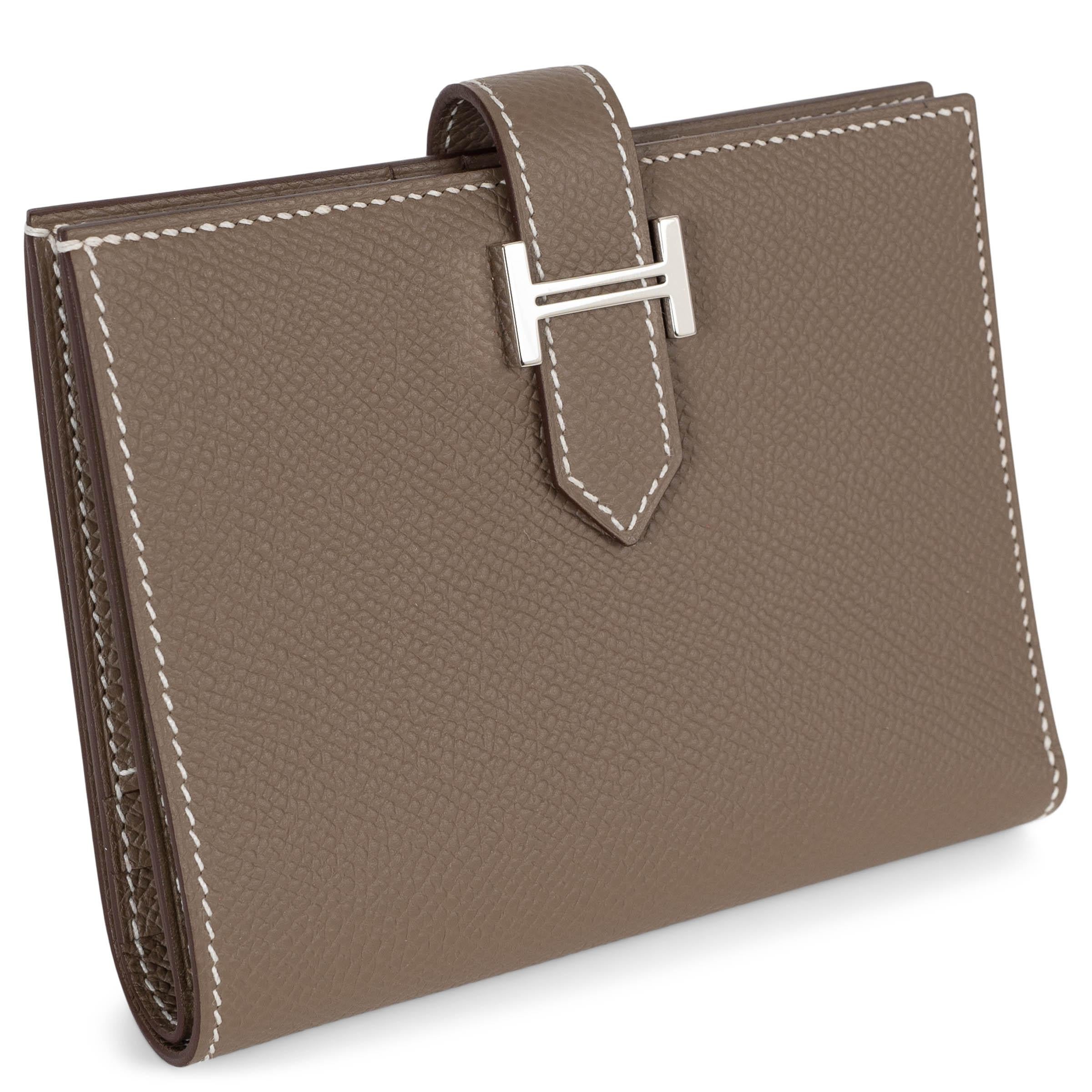 Questo portafoglio Hermès Bearn Compact in pelle Etoupe (taupe) Veau Epsom, autentico al 100%, è un accessorio senza tempo di raffinata fattura. Caratterizzata da una silhouette strutturata, si chiude con una linguetta in pelle e una chiusura ad H