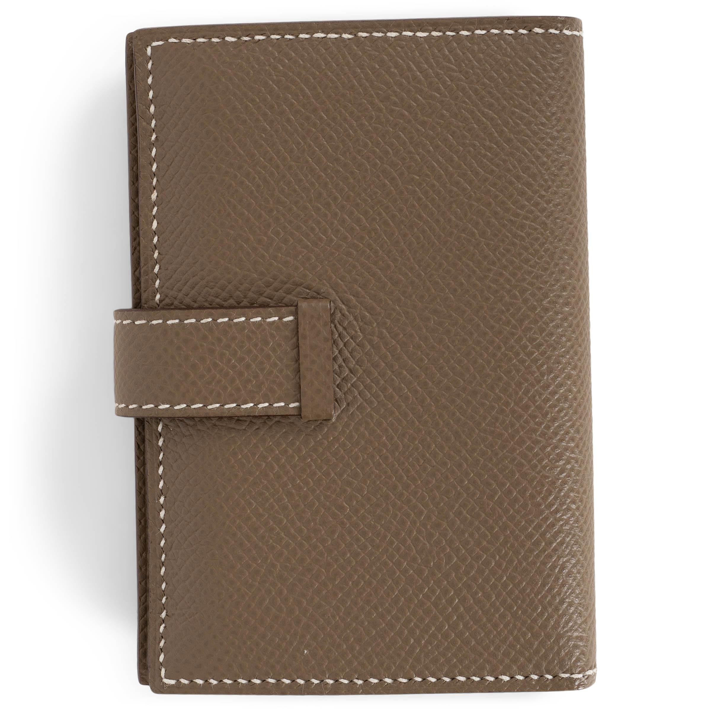 This 100% authentic Hermès Bearn Mini wallet in Etoupe (taupe) Veau Epsom leather embodies timeless sophistication. Designed with a sleek silhouette, it closes with a leather tab and palladium-plated openwork H closure. The interior is lined in