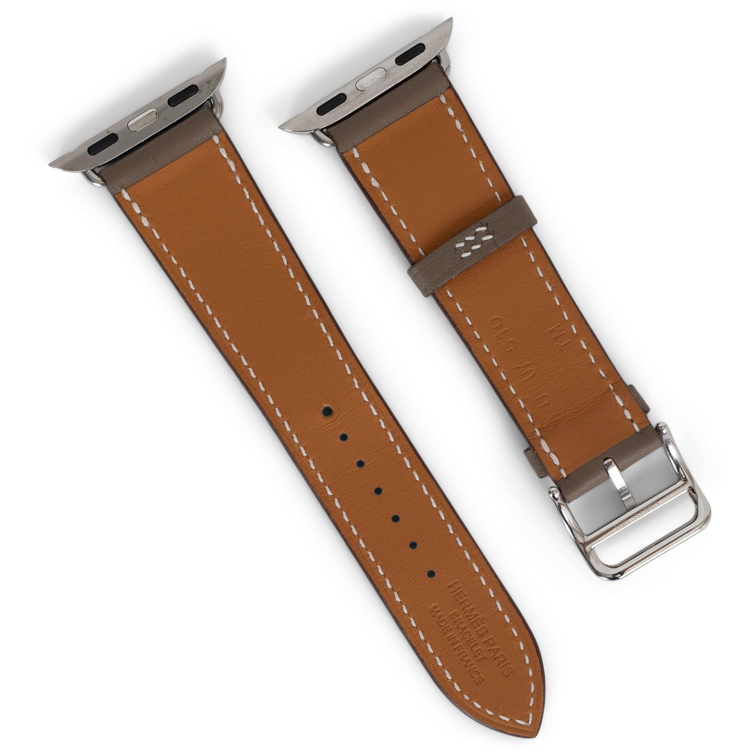 Dieses 100% authentische Hermès Apple Watch Single Tour Armband 42mm aus Etoupe (taupe) Veau Swift Leder kombiniert zeitlose Handwerkskunst mit moderner Technologie. Die kontrastierenden weißen Nähte und die Palladiumbeschläge sorgen für eine