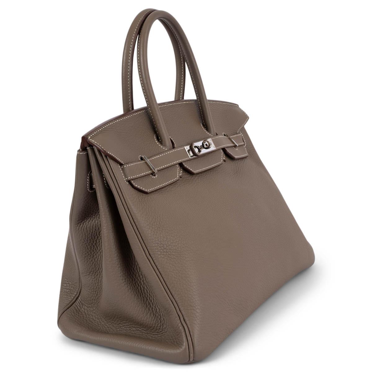 100% authentic Hermès Birkin 35 bag in Etoupe (taupe) Veau Togo leather with palladium hardware. Lined in Chevre (goat skin) with an open pocket against the front and a zipper pocket against the back. Has been carried with a slight dent in the flap