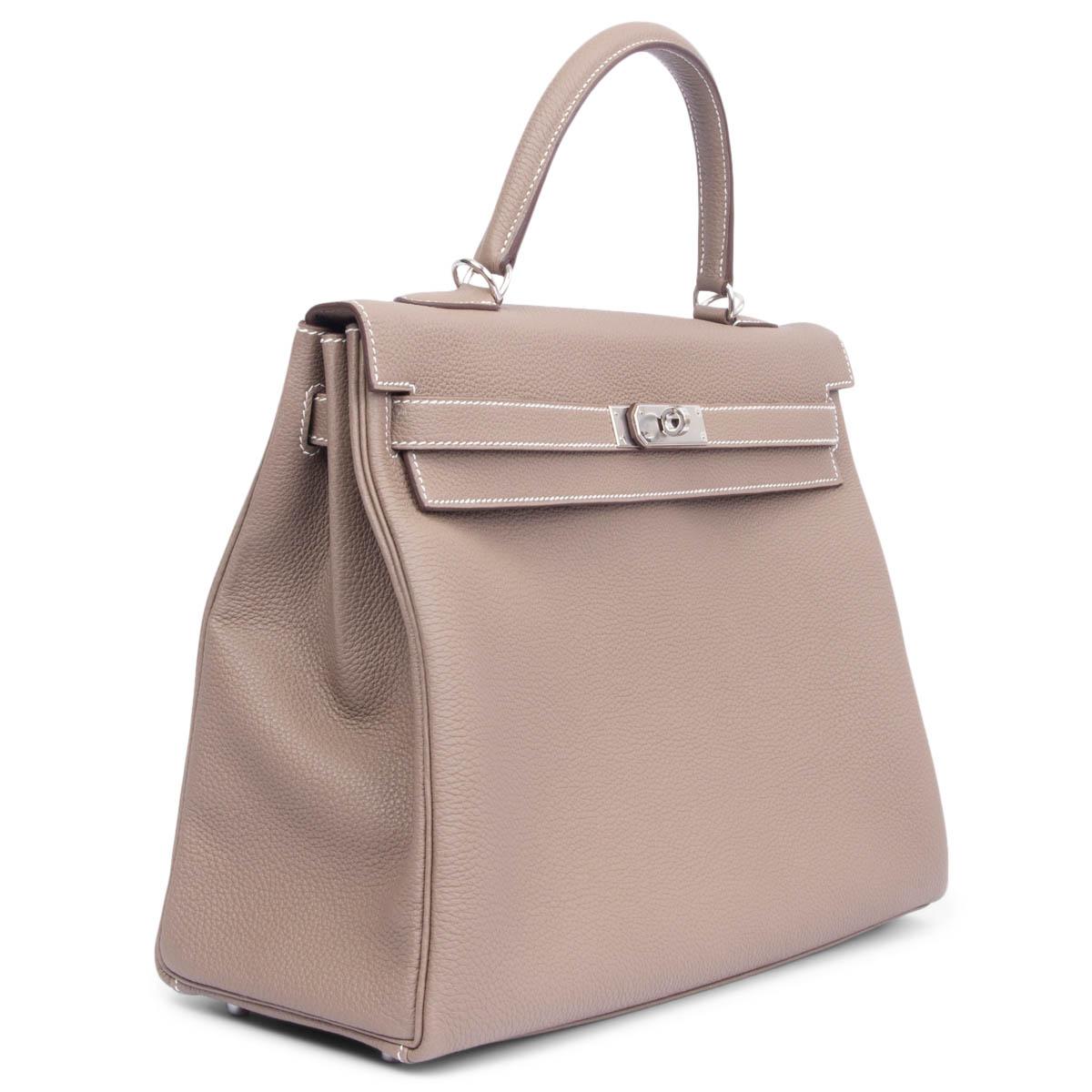 100% authentic Hermès Kelly 35 Retourne bag in Etoupe Togo leather with contrasting white stitching palladium hardware. Lined in Chèvre (goat skin) leather with two open pockets against the front and a zipper pocket against the back. Brand new -