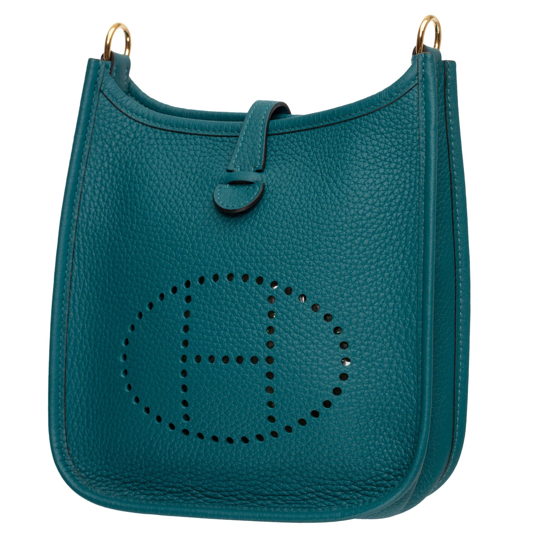 La Hermes Evelyne 16 cm de piel Vert Bosphore Clemence con herrajes dorados es una fusión perfecta de estilo y practicidad. Meticulosamente diseñado, este bolso cruzado compacto incorpora la rica y duradera piel Vert Bosphore Clemence, complementada