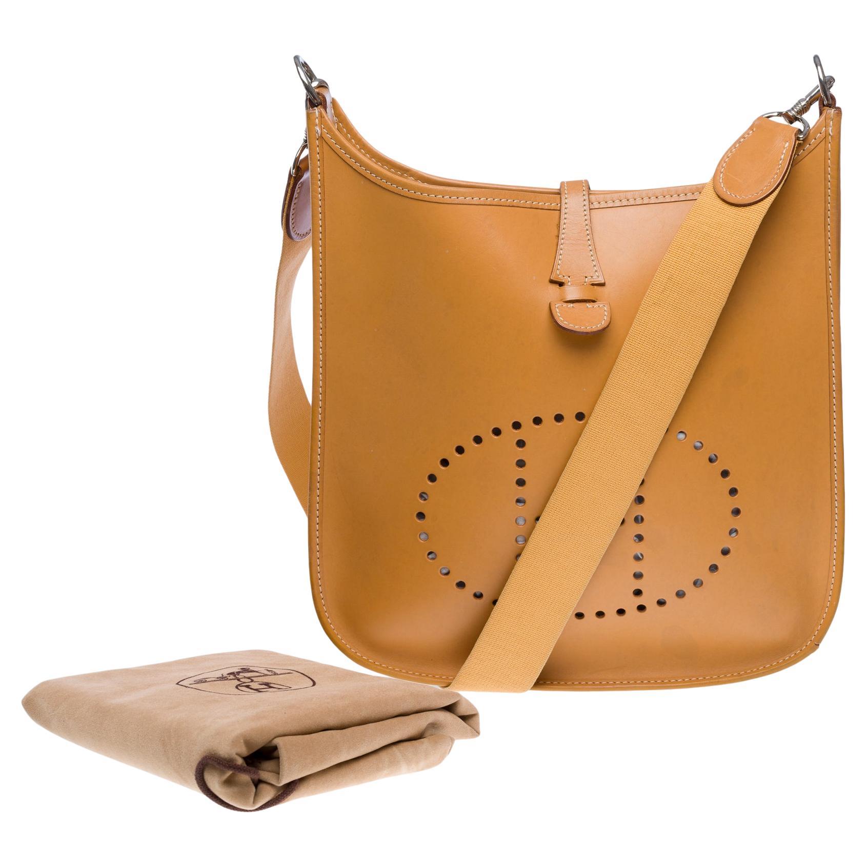 Iconic​ ​and​ ​rare​ ​Hermes​ ​Evelyne​ ​29​ ​shoulder​ ​bag​ ​in​ ​natural​ ​cowhide​ ​leather,​ ​palladium​ ​silver​ ​metal​ ​trim,​ ​removable​ ​beige​ ​canvas​ ​shoulder​ ​strap​ ​allowing​ ​for​ ​shoulder​ ​or​ ​crossbody​ ​wear.

Closure​