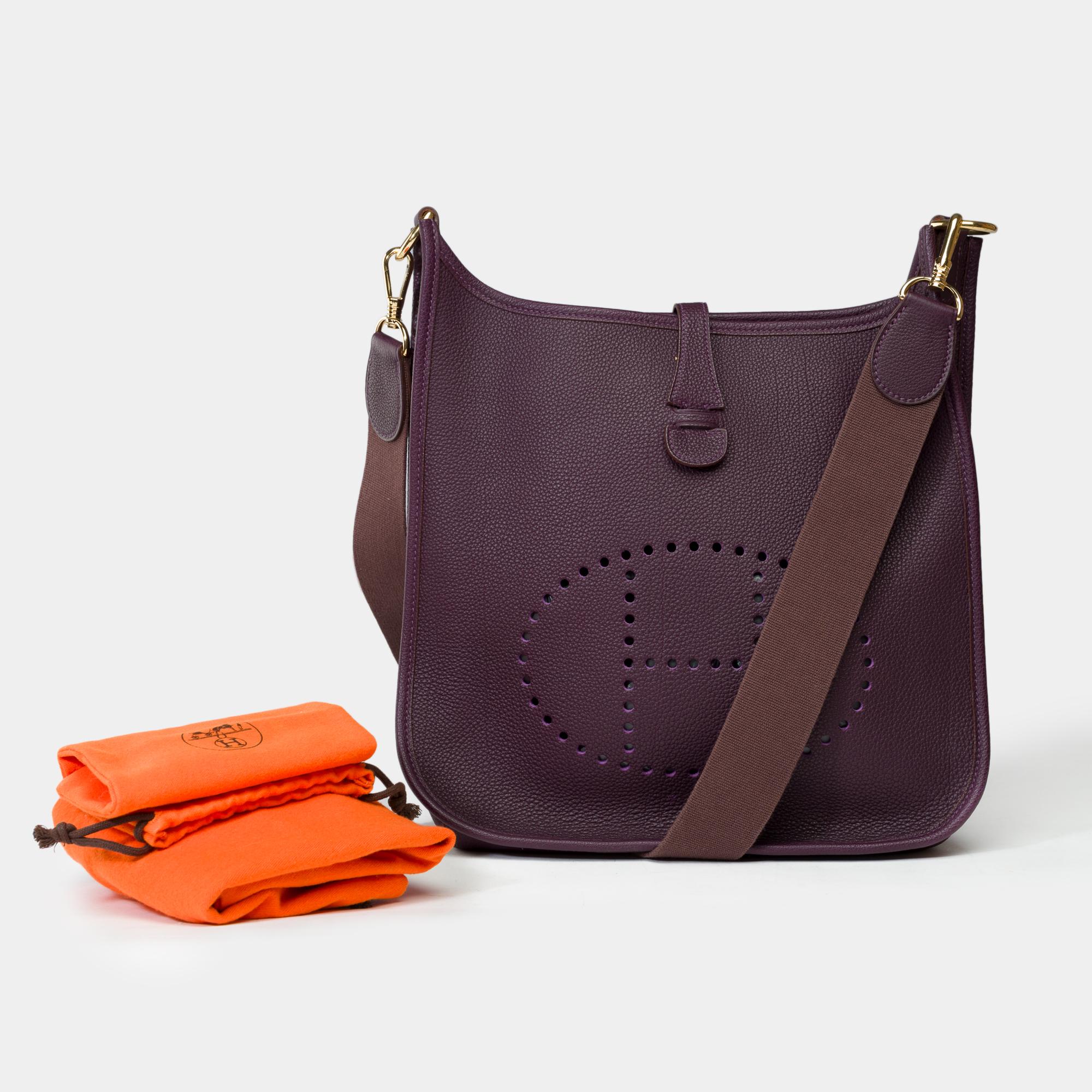 Iconic Hermes Evelyne 29 shoulder bag in purple Togo leather, gold metal trim, a removable strap in purple canvas allowing a shoulder or crossbody carry

Press-stud closure on flap
Interior in purple suede
Signature : 