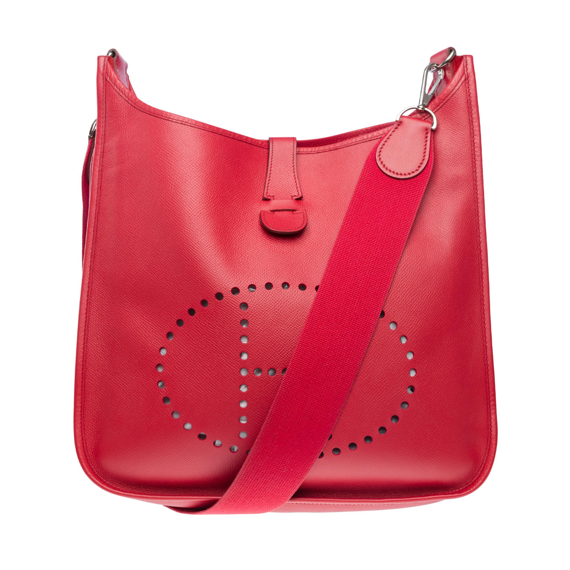 Iconic​ ​Hermès​ ​Evelyne​ ​GM​ ​shoulder​ ​bag​ ​in​ ​Red​ ​Vermilion​ ​Epsom​ ​leather,​ ​silver​ ​metal​ ​trim,​ ​a​ ​red​ ​canvas​ ​removable​ ​strap​ ​for​ ​a​ ​shoulder​ ​or​ ​crossbody​ ​carry

Press-stud​ ​closure​ ​on​ ​flap
Red​ ​suede​