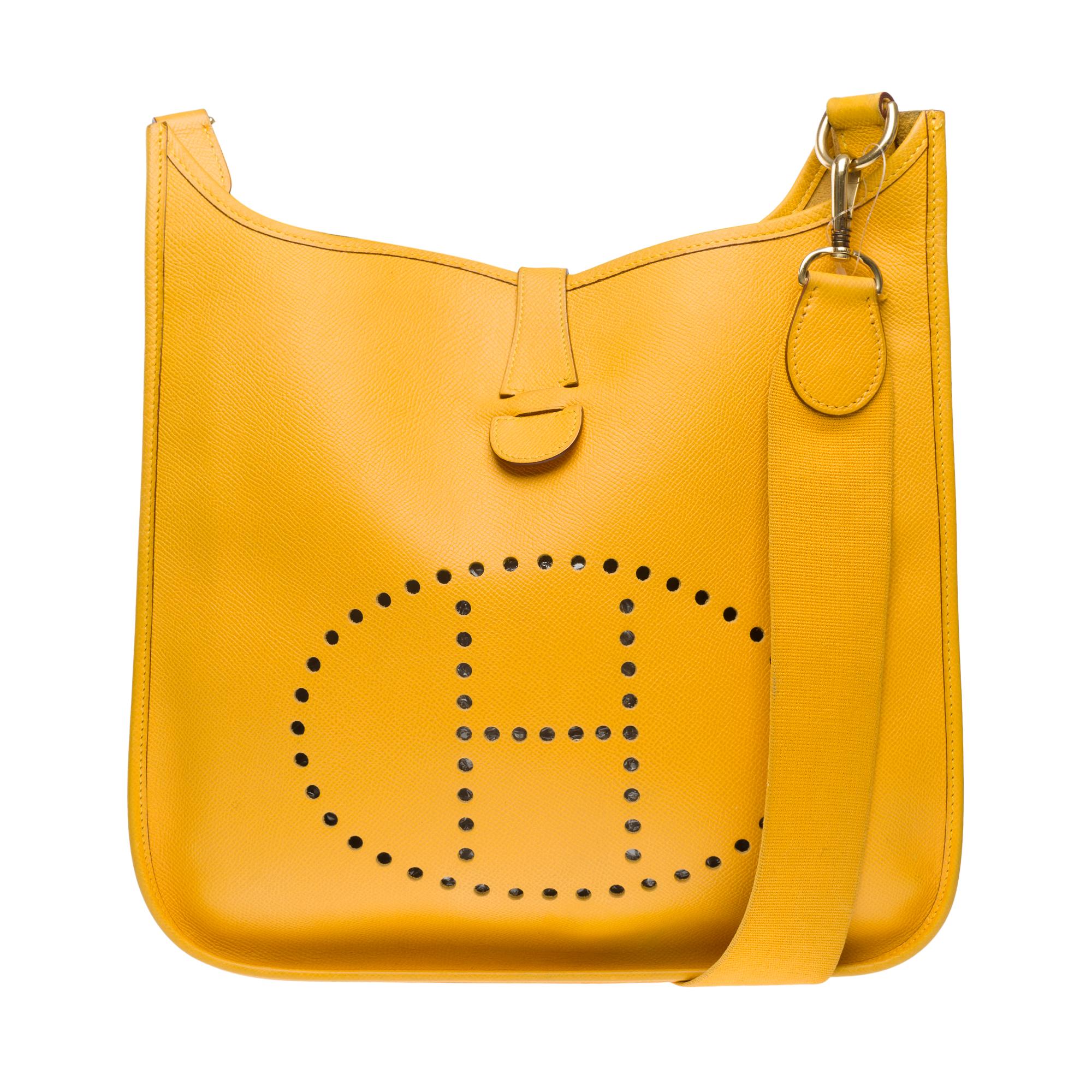 The​ ​Iconic​ ​Hermes​ ​Evelyne​ ​GM​ ​shoulder​ ​bag​ ​in​ ​Yellow​ ​gold​ ​(jaune​ ​d'or)​ ​Courchevel​ ​leather​ ​,​ ​gold​ ​metal​ ​trim,​ ​a​ ​removable​ ​shoulder​ ​strap​ ​in​ ​yellow​ ​canvas​ ​allowing​ ​a​ ​shoulder​ ​or​ ​crossbody​