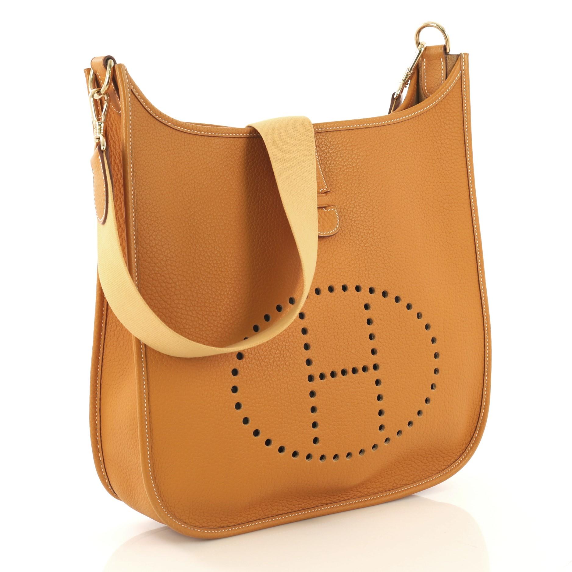 This Hermes Evelyne Crossbody Gen I Fjord GM, crafted from Natural Sable Fjord leather, features a perforated H design at the front, textile shoulder strap and gold hardware. It opens to a Natural Sable raw leather interior. Date stamp reads: F