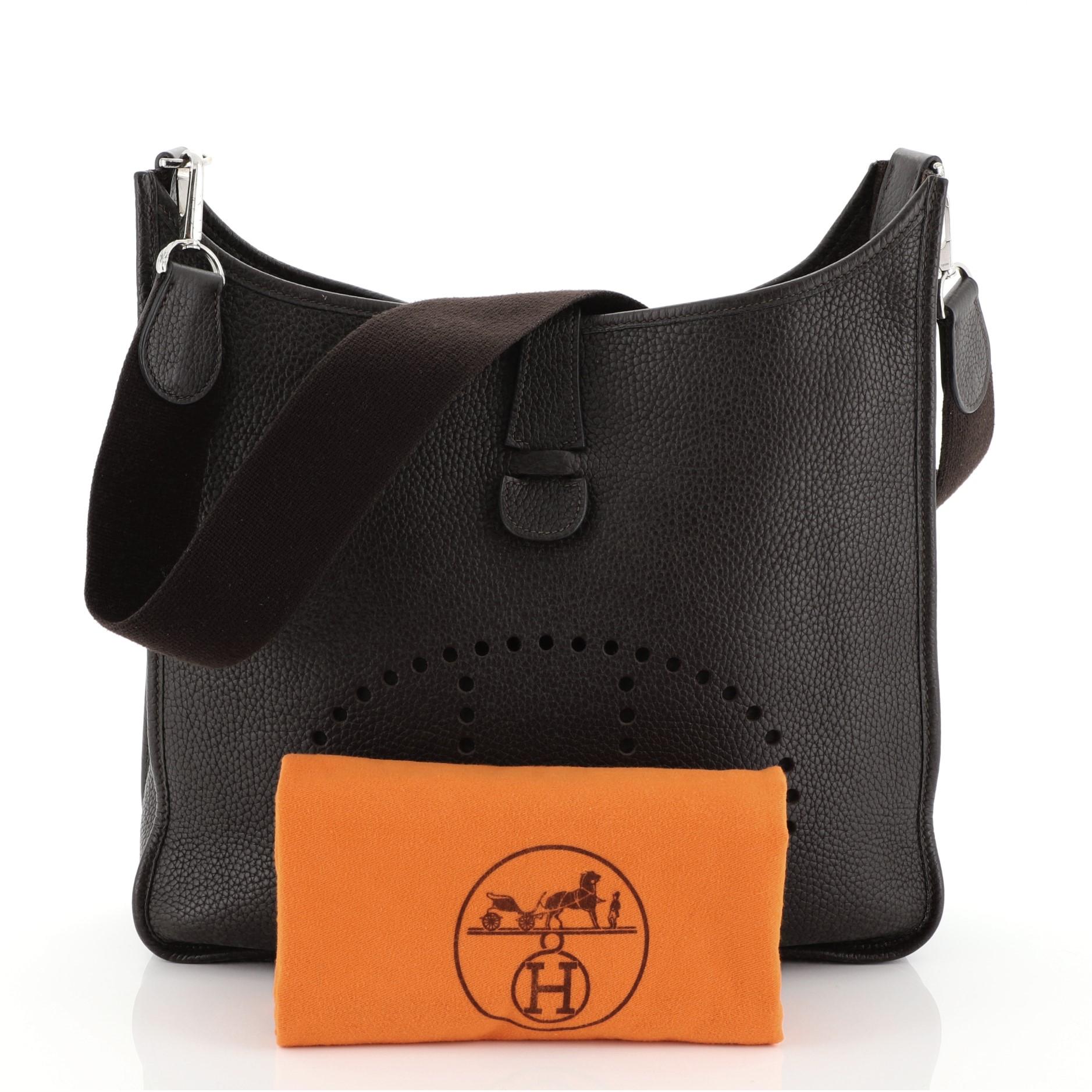 This Hermes Evelyne Crossbody Gen II Clemence GM, crafted in Ebene brown Clemence Leather, features perforated H design at the front, long crossbody strap, and palladium hardware. It opens to an Ebene brown raw leather interior. Date stamp reads: I