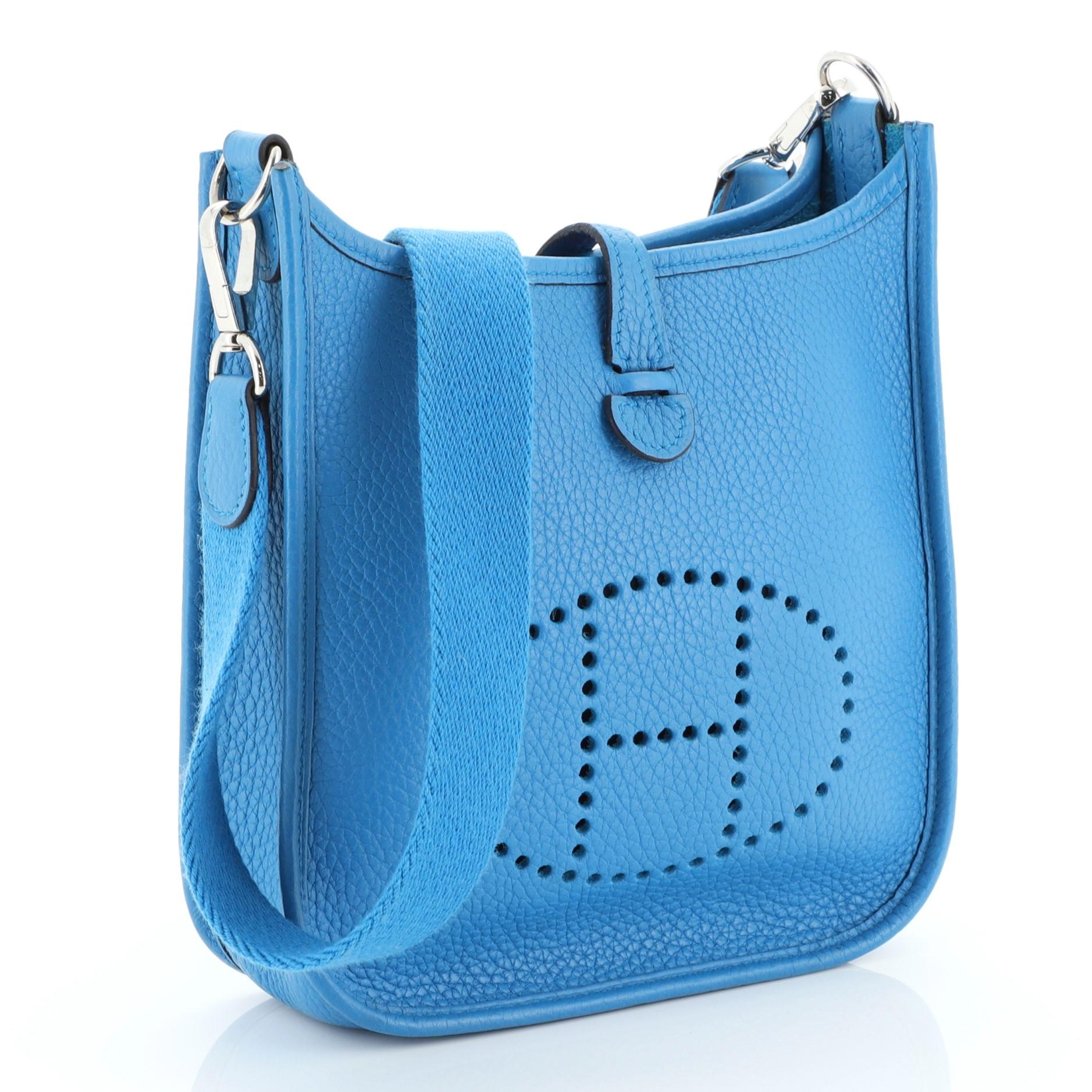 This Hermes Evelyne Crossbody Gen III Clemence TPM, crafted in Bleu Zanzibar blue Clemence leather, features a signature perforated H design at the front, textile shoulder strap and palladium hardware. It opens to a Bleu Zanzibar blue raw leather